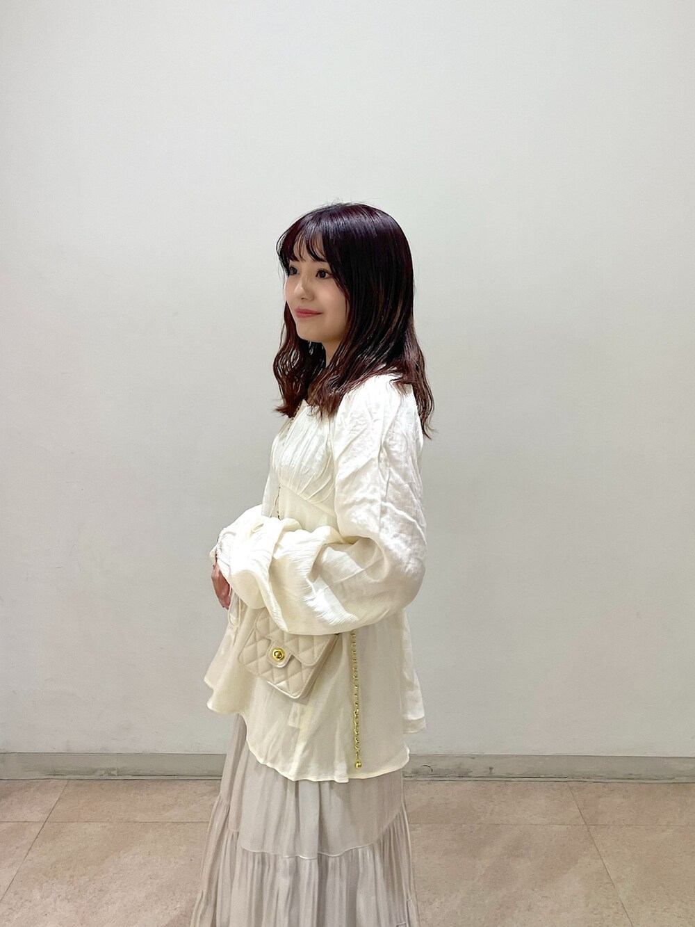 ホワイト系のショルダーバッグ、ホワイト系のシャツ/ブラウス、ホワイト系のスカートを着用したレディースの冬コーディネートの5枚目の写真