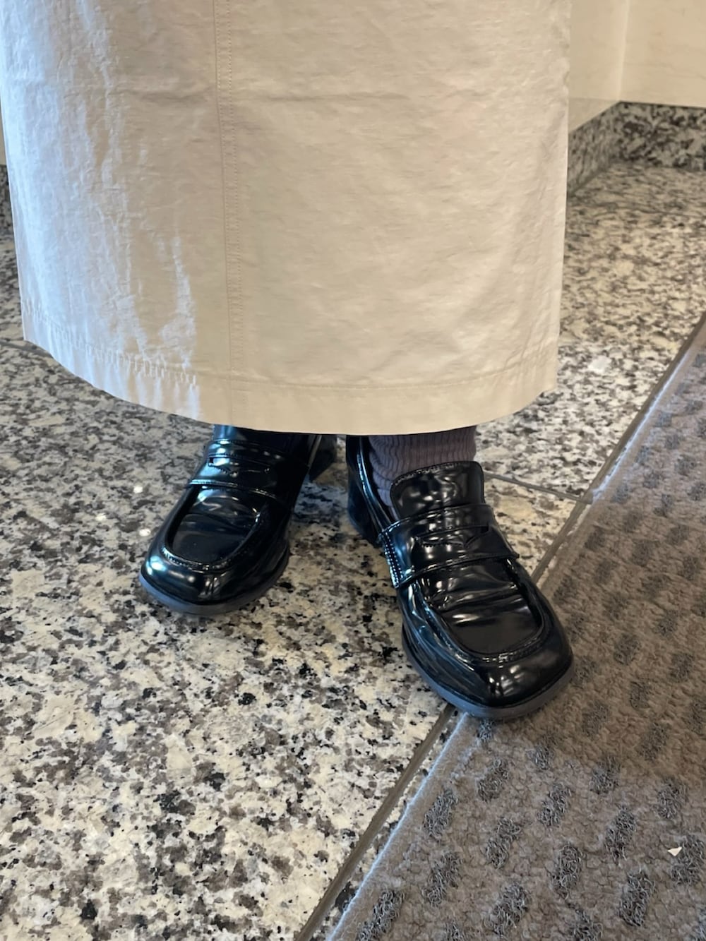 ベージュ系のトレンチコート、ホワイト系のニット/セーター、ベージュ系のショルダーバッグを着用したレディースの春コーディネートの10枚目の写真