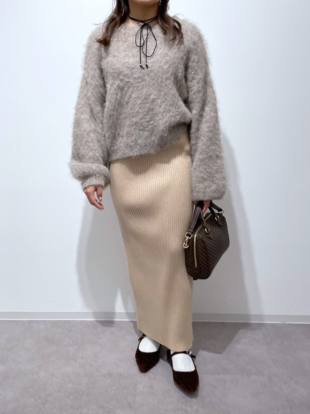 ベージュ系のニット/セーター、ゴールド系のスカート、ブラウン系のバレエシューズを着用したレディースの冬コーディネートの7枚目の写真