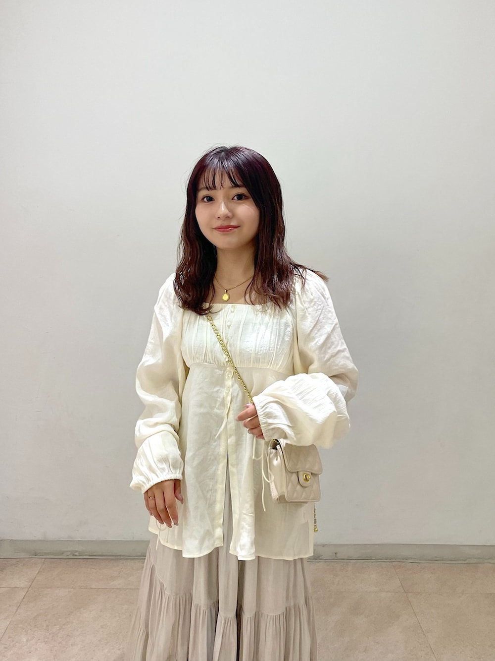 ホワイト系のショルダーバッグ、ホワイト系のシャツ/ブラウス、ホワイト系のスカートを着用したレディースの冬コーディネートの4枚目の写真