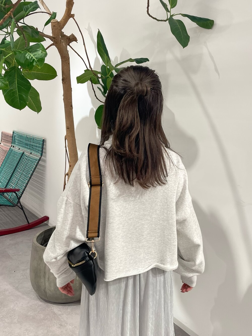 シルバー系のスカート、ブラック系のボディバッグ/ウエストポーチ、グレー系のスウェットを着用したレディースの秋コーディネートの6枚目の写真