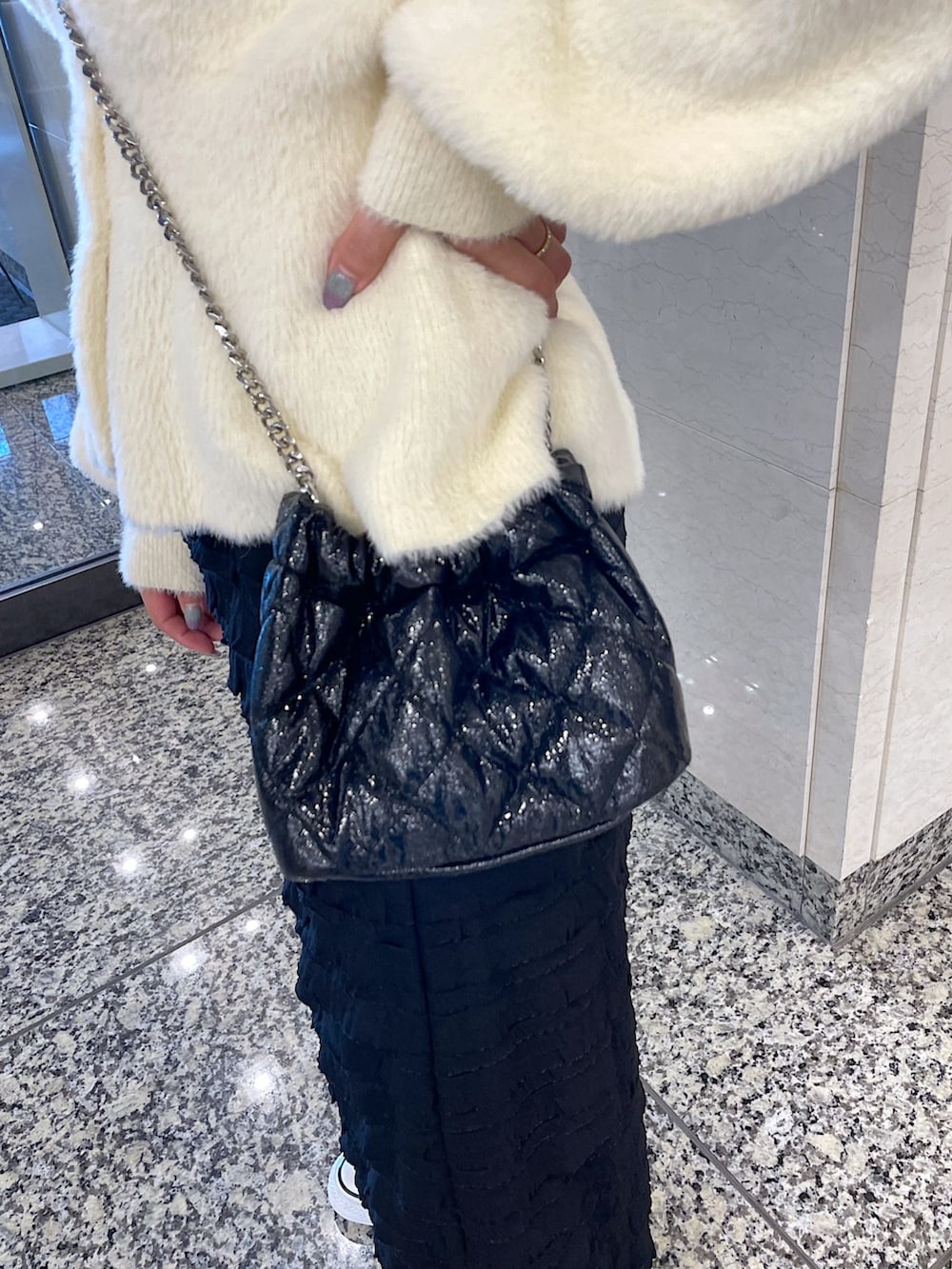 ホワイト系のカーディガン/ボレロ、ブラック系のスカート、ブラック系のショルダーバッグを着用したレディースの冬コーディネートの9枚目の写真