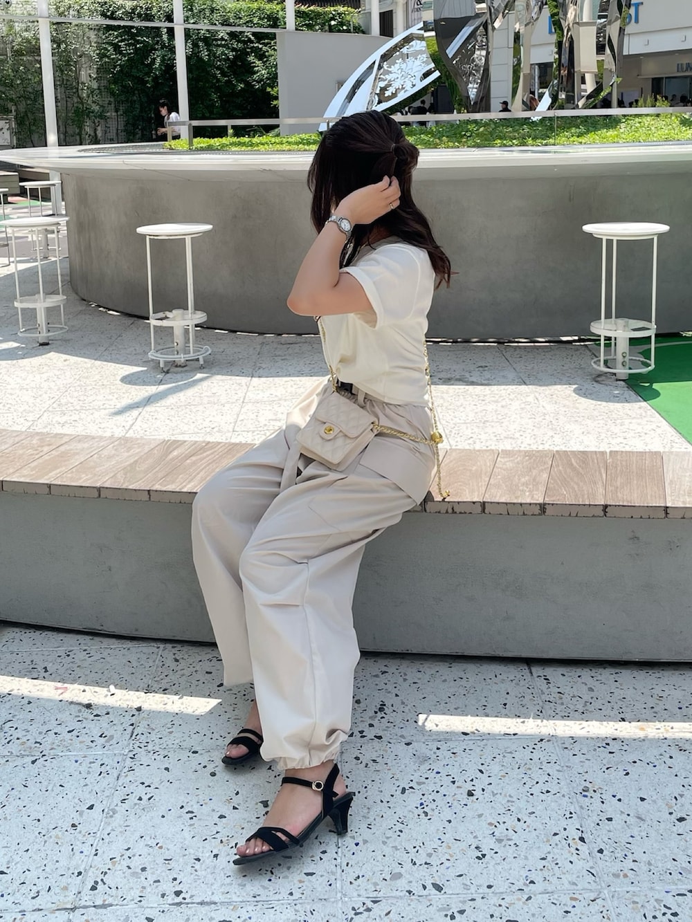 ベージュ系のカーゴパンツ、ホワイト系のTシャツ/カットソー、ホワイト系のショルダーバッグを着用したレディースの夏コーディネートの4枚目の写真