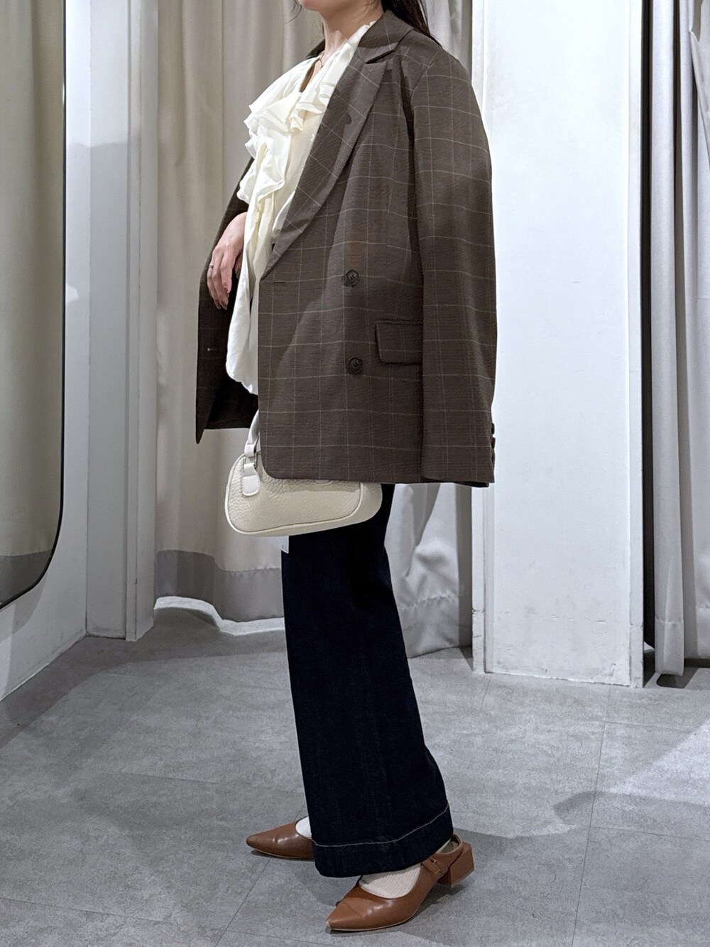 ブラウン系のテーラードジャケット、ホワイト系のシャツ/ブラウス、ブルー系のデニムパンツを着用したレディースの秋コーディネートの6枚目の写真