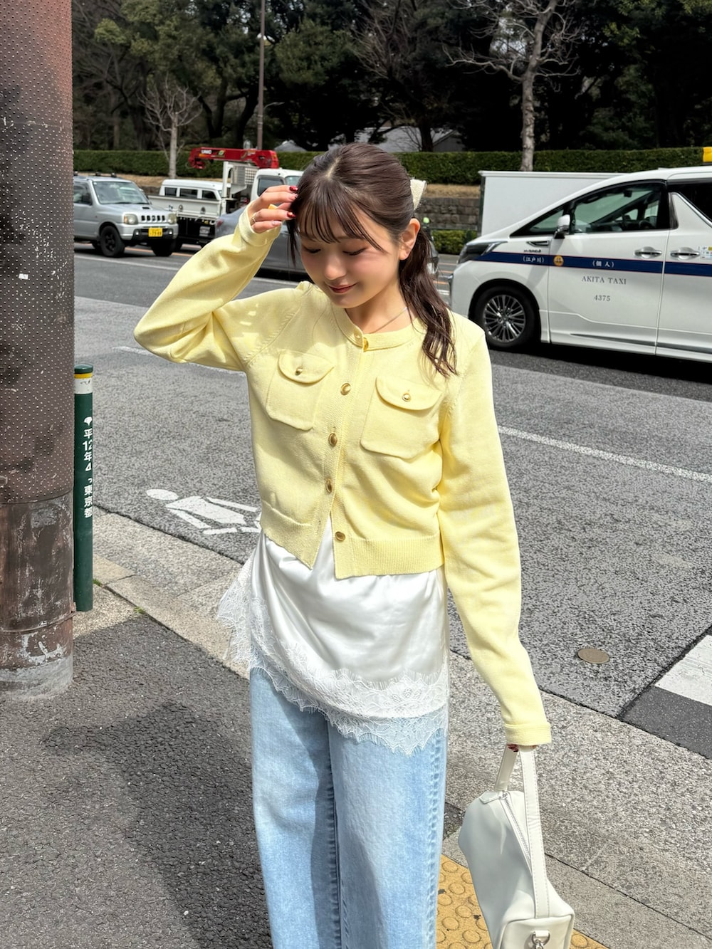 ホワイト系のニット/セーター、ホワイト系のキャミソール、ブルー系のデニムパンツを着用したレディースの春コーディネートの3枚目の写真