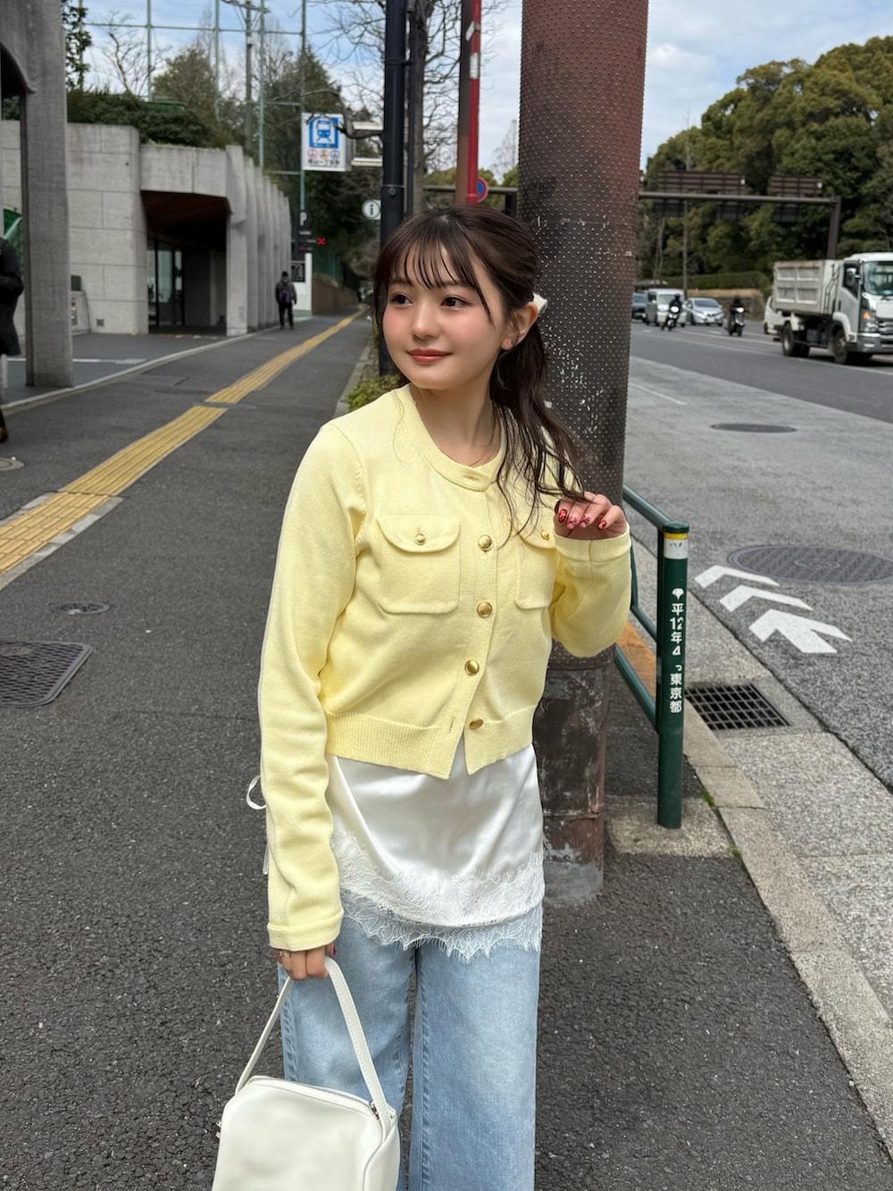 ホワイト系のニット/セーター、ホワイト系のキャミソール、ブルー系のデニムパンツを着用したレディースの春コーディネートの4枚目の写真