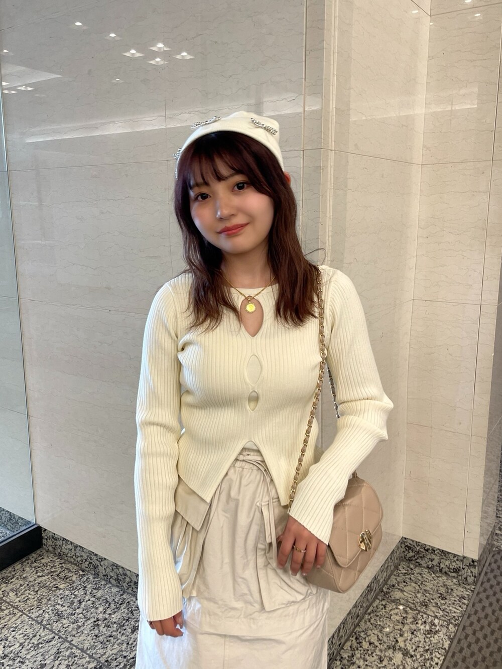 ベージュ系のトレンチコート、ホワイト系のニット/セーター、ベージュ系のショルダーバッグを着用したレディースの春コーディネートの8枚目の写真