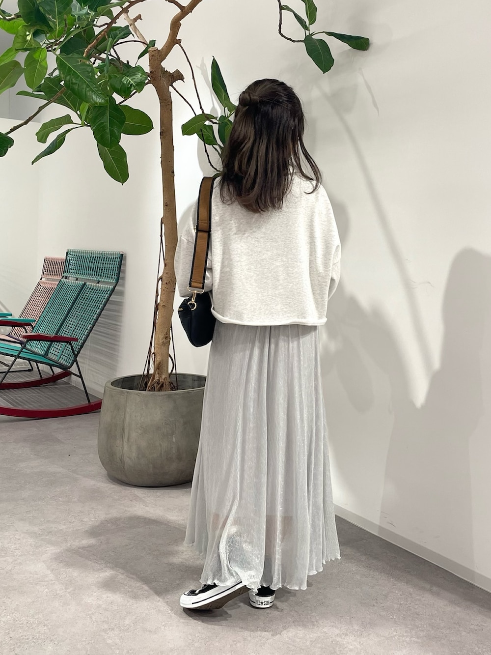 シルバー系のスカート、ブラック系のボディバッグ/ウエストポーチ、グレー系のスウェットを着用したレディースの秋コーディネートの3枚目の写真