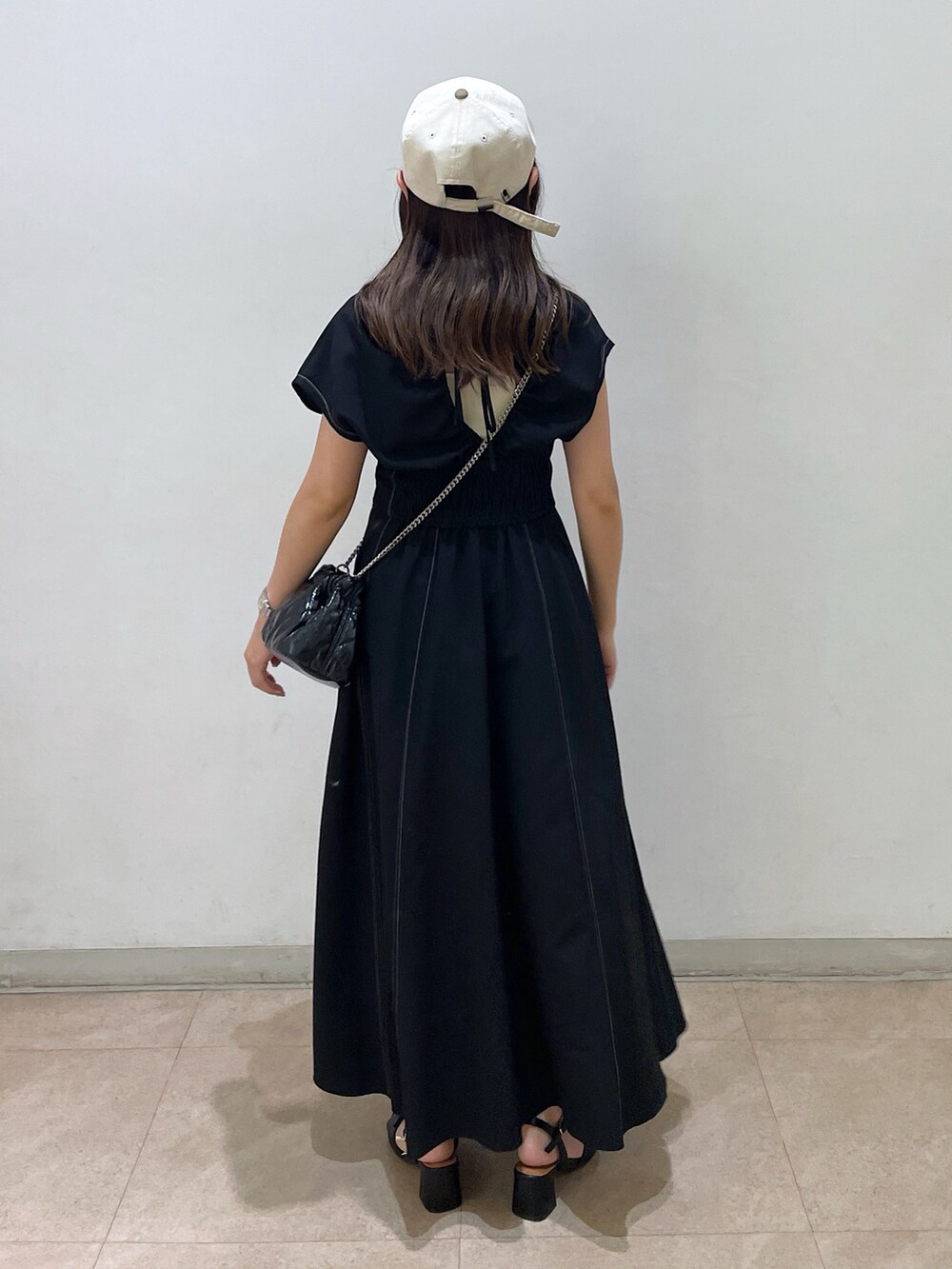 ブラック系のワンピース、ブラック系のショルダーバッグ、ブラック系のサンダルを着用したレディースの夏コーディネートの3枚目の写真