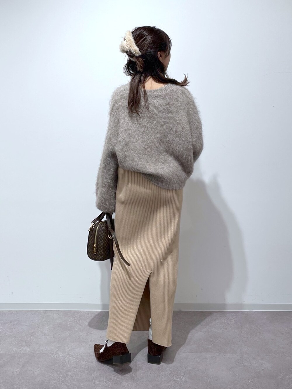 ベージュ系のニット/セーター、ゴールド系のスカート、ブラウン系のバレエシューズを着用したレディースの冬コーディネートの3枚目の写真