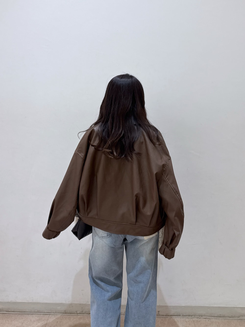 ブラウン系のブルゾン、ホワイト系のシャツ/ブラウス、ホワイト系のキャミソールを着用したレディースの春コーディネートの5枚目の写真