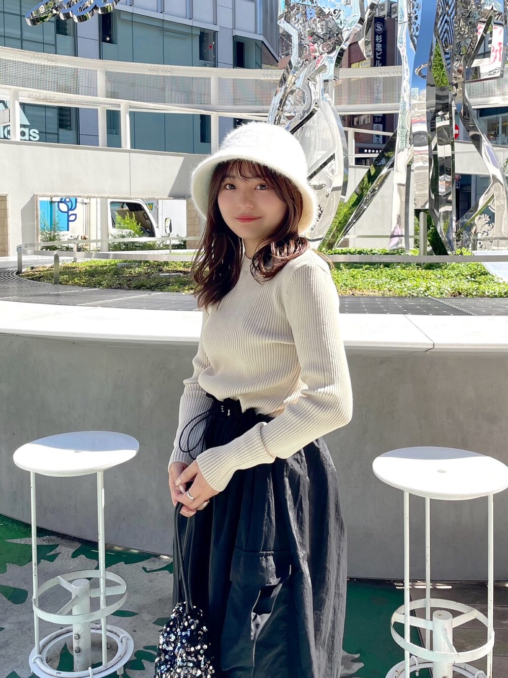 ホワイト系のワンピース、ブラック系のハンドバッグ、ホワイト系のブーツを着用したレディースの秋コーディネートの4枚目の写真