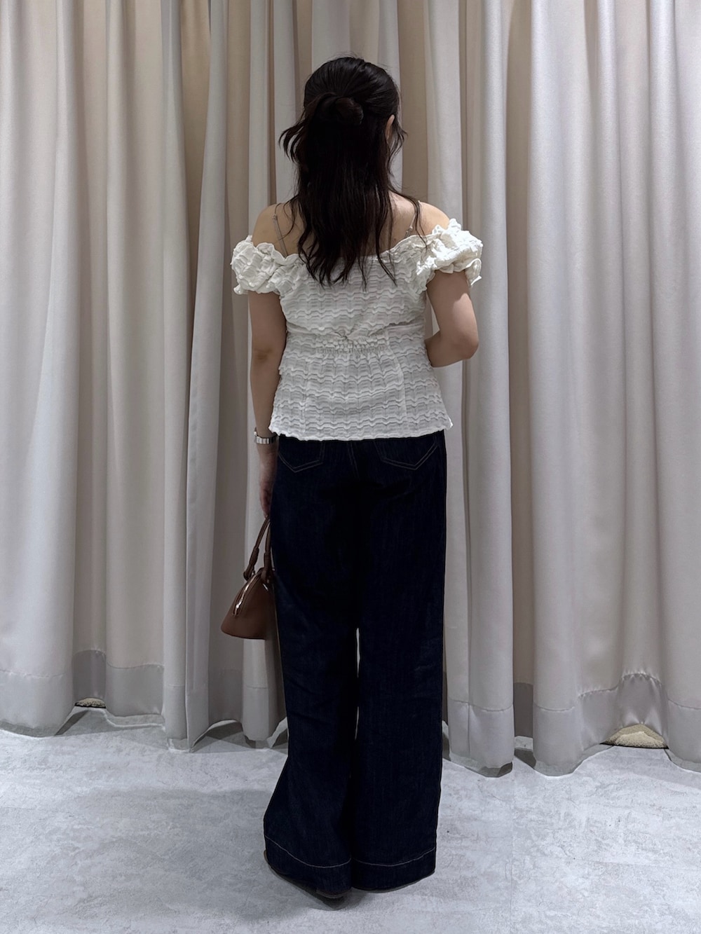 ブラウン系のサンダル、ブルー系のデニムパンツ、ブラウン系のボストンバッグを着用したレディースの夏コーディネートの3枚目の写真