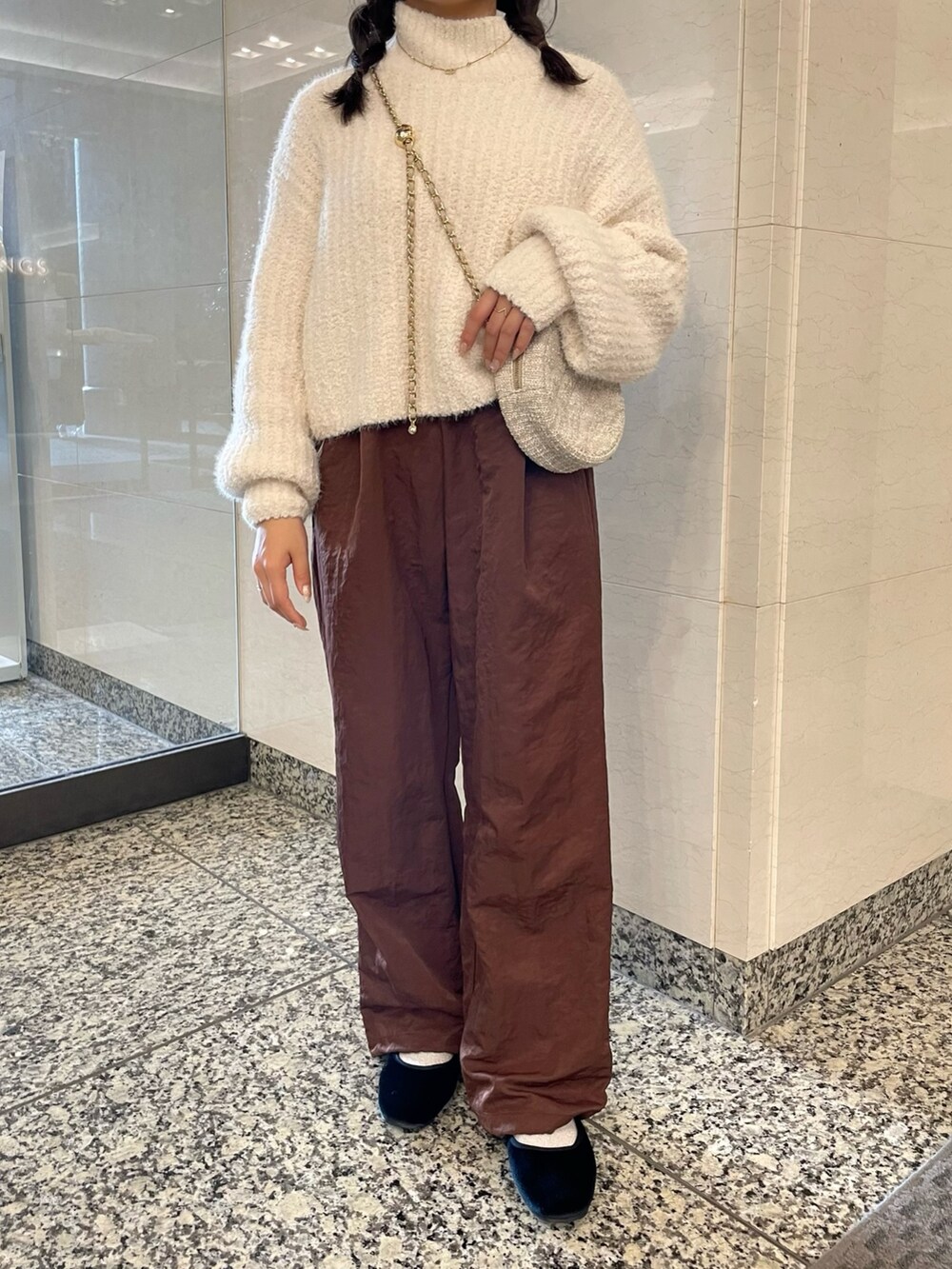ホワイト系のニット/セーター、ブラウン系のその他パンツ、ベージュ系のショルダーバッグを着用したレディースの秋コーディネートの7枚目の写真