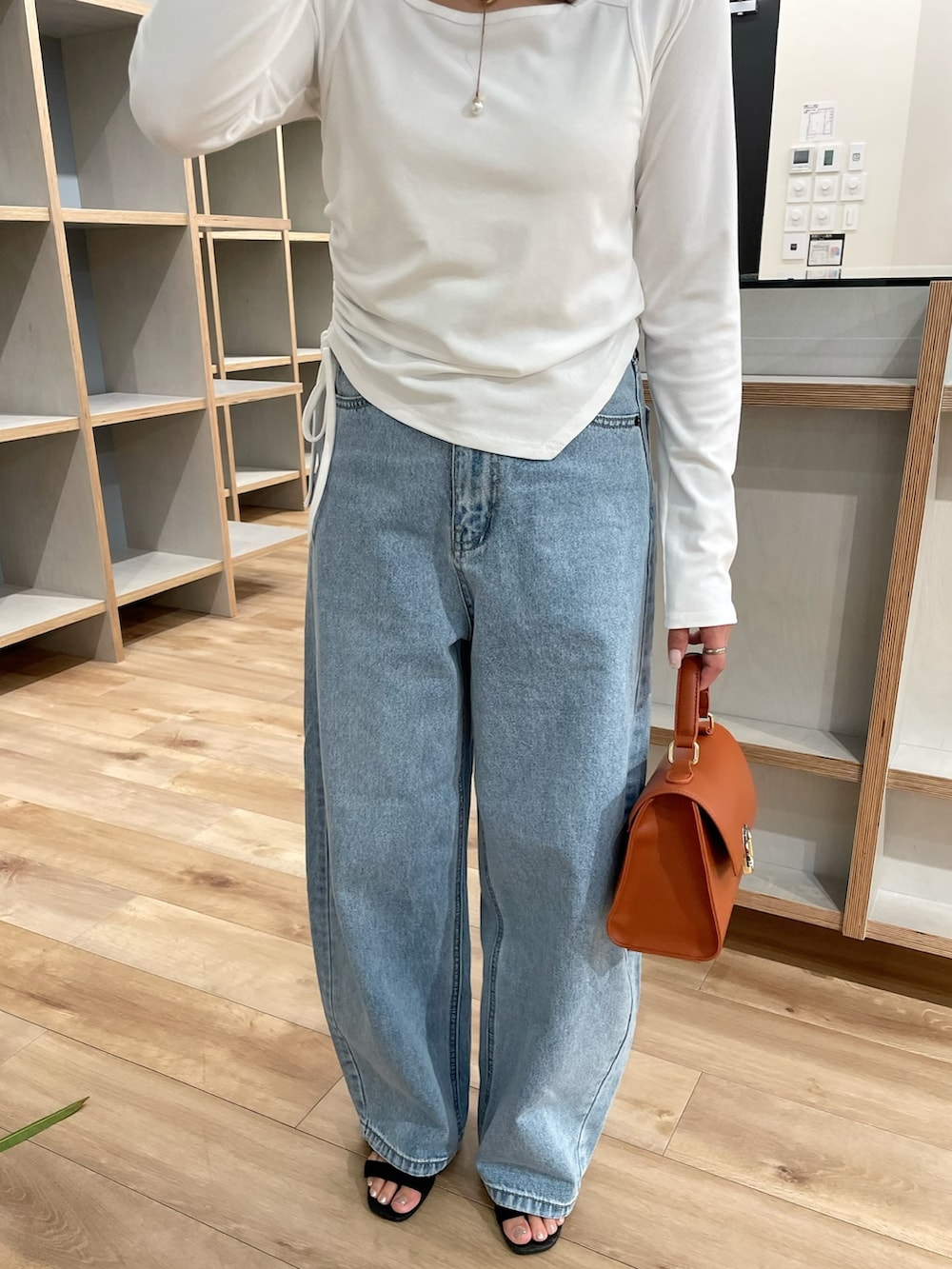 ホワイト系のTシャツ/カットソー、ブルー系のデニムパンツ、ブラウン系のショルダーバッグを着用したレディースの夏コーディネートの6枚目の写真