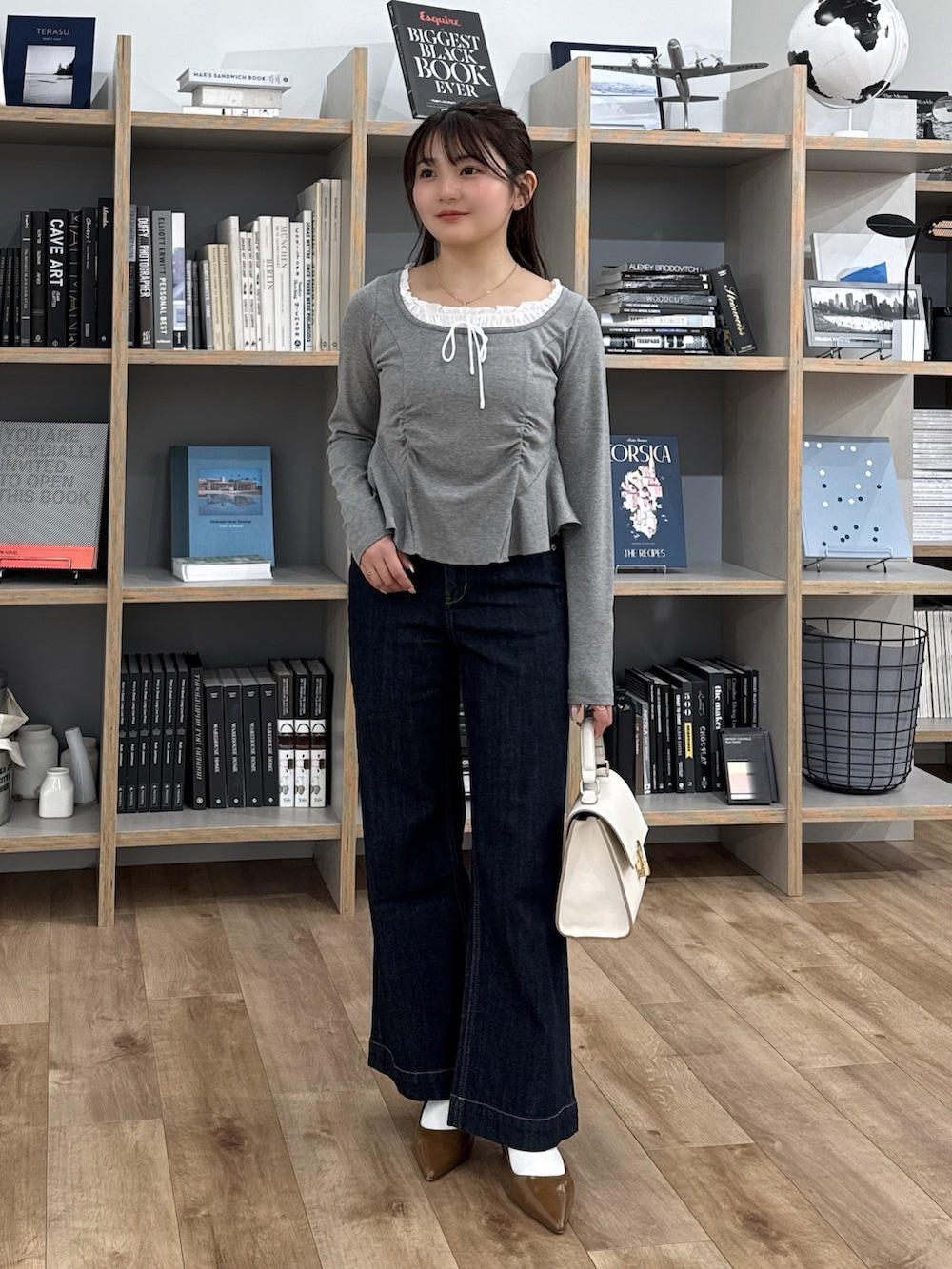 グレー系のTシャツ/カットソー、ブラウン系のパンプス、ホワイト系のトートバッグを着用したレディースの冬コーディネートの4枚目の写真