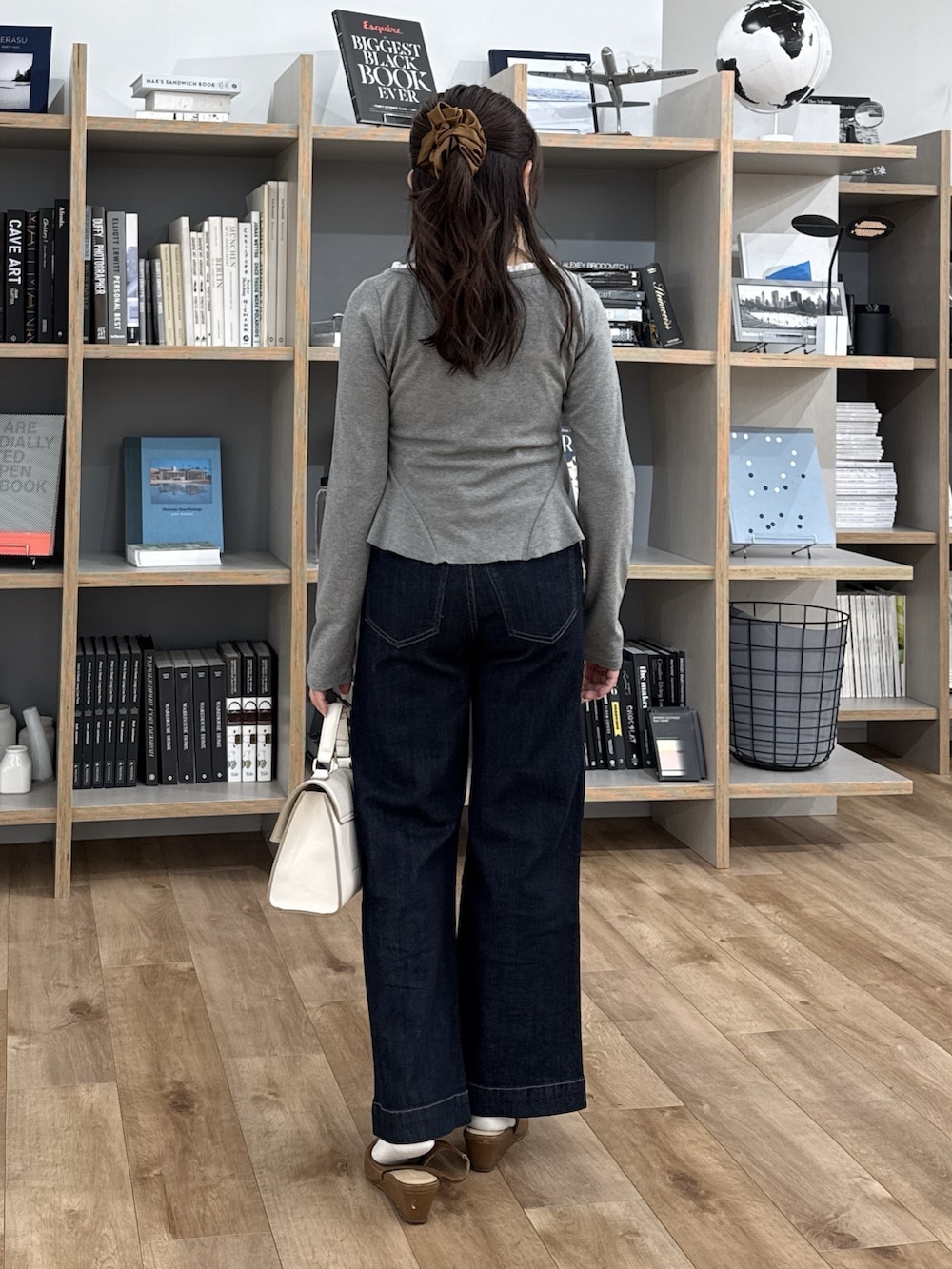 グレー系のTシャツ/カットソー、ブラウン系のパンプス、ホワイト系のトートバッグを着用したレディースの冬コーディネートの6枚目の写真