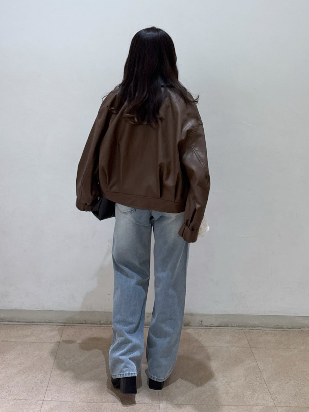 ブラウン系のブルゾン、ホワイト系のシャツ/ブラウス、ホワイト系のキャミソールを着用したレディースの春コーディネートの3枚目の写真