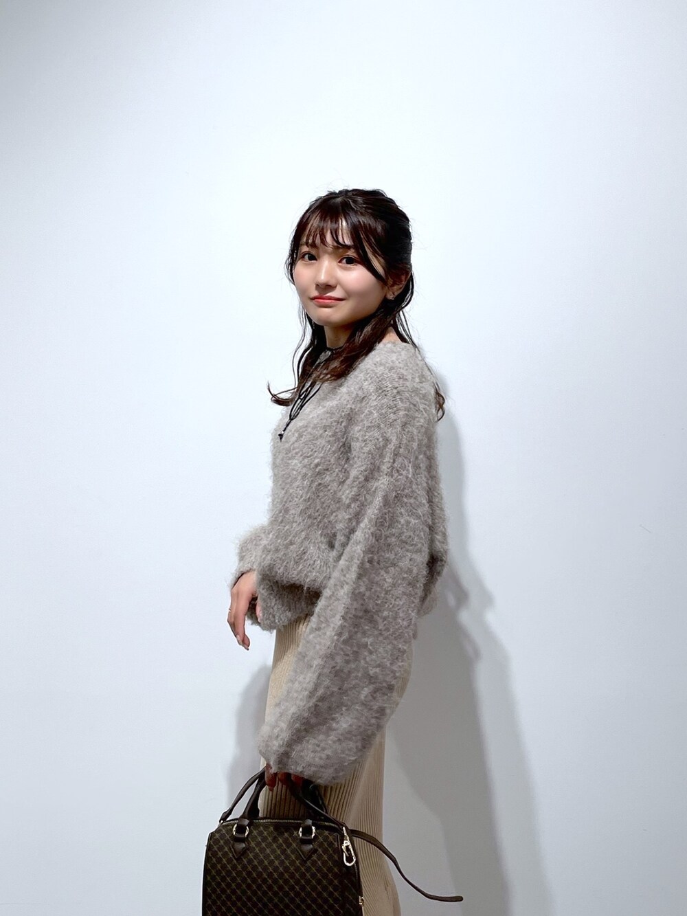 ベージュ系のニット/セーター、ゴールド系のスカート、ブラウン系のバレエシューズを着用したレディースの冬コーディネートの5枚目の写真