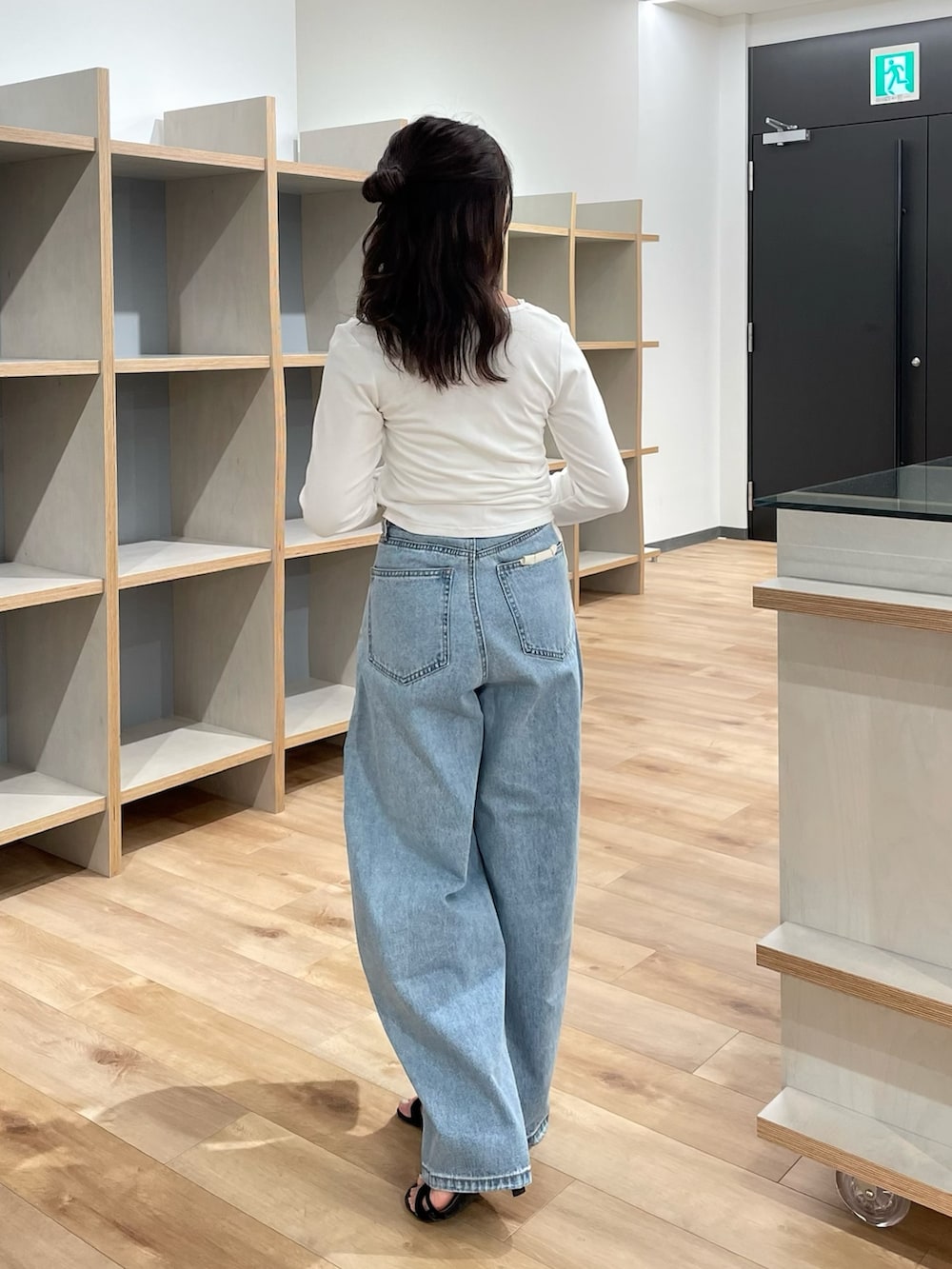 ホワイト系のTシャツ/カットソー、ブルー系のデニムパンツ、ブラウン系のショルダーバッグを着用したレディースの夏コーディネートの3枚目の写真
