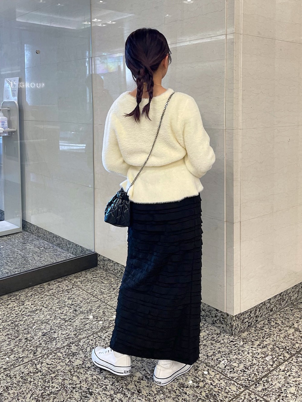 ホワイト系のカーディガン/ボレロ、ブラック系のスカート、ブラック系のショルダーバッグを着用したレディースの冬コーディネートの3枚目の写真