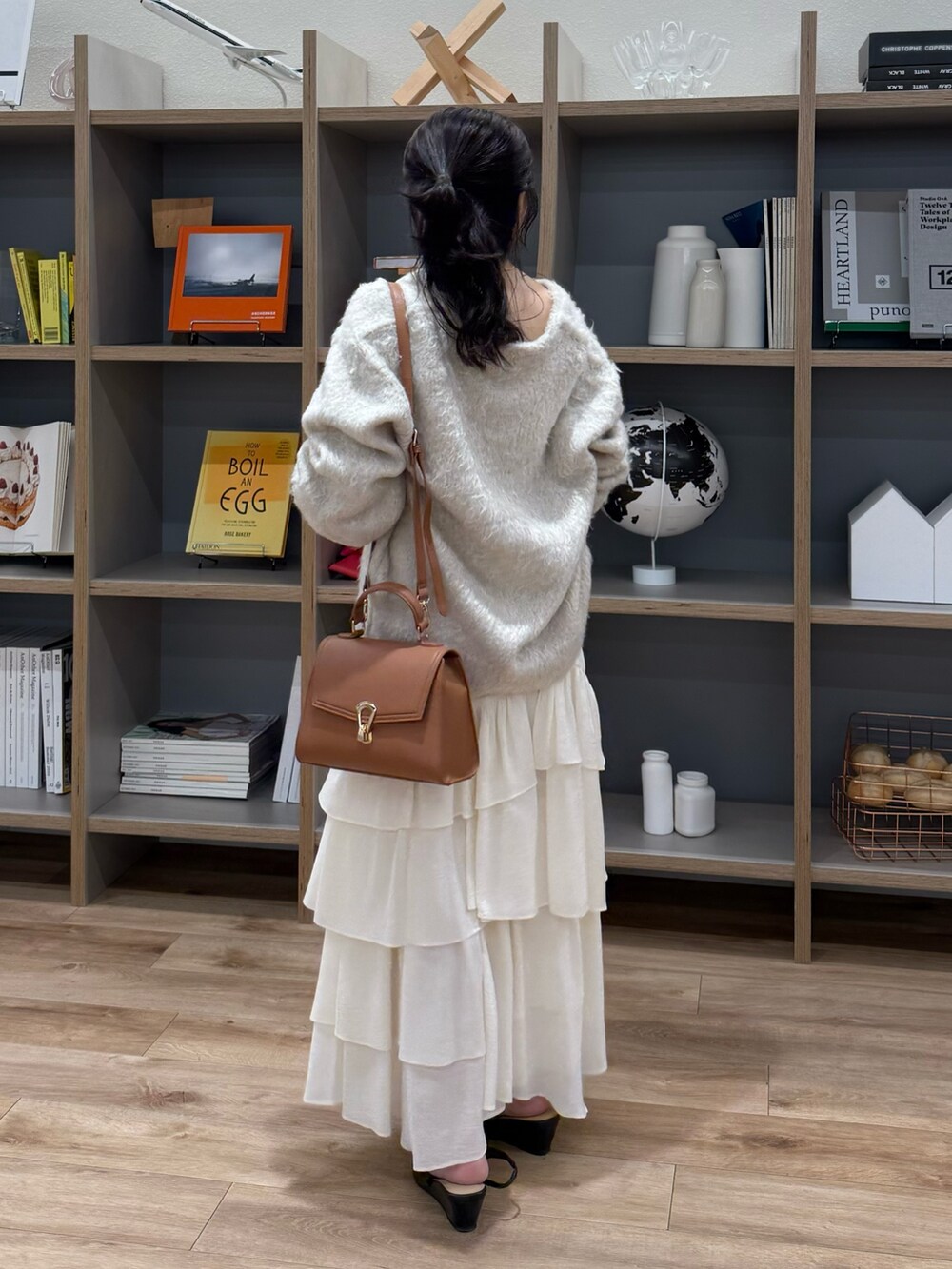 ベージュ系のニット/セーター、ホワイト系のスカート、ベージュ系のトートバッグを着用したレディースの秋コーディネートの3枚目の写真