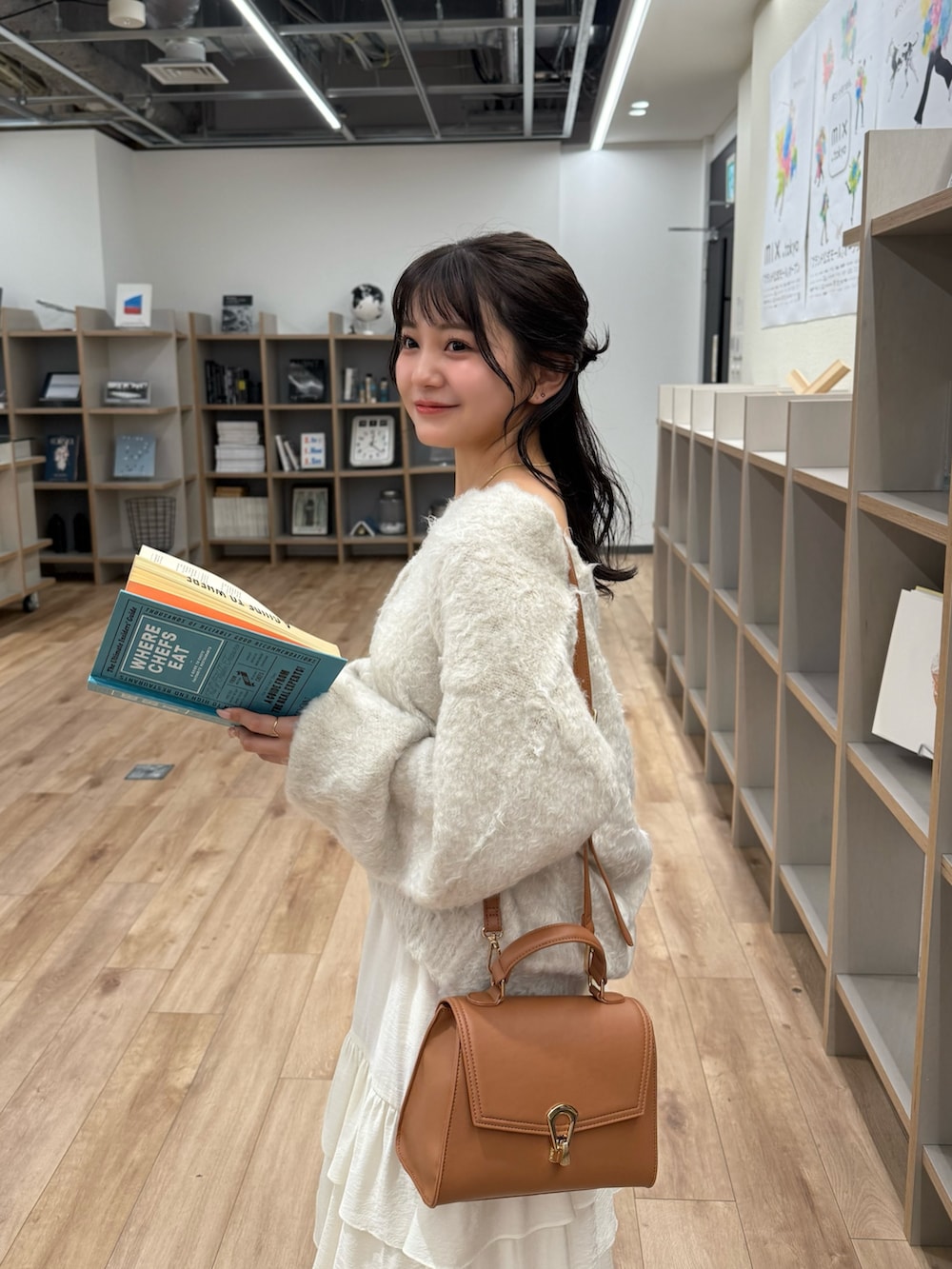 ベージュ系のニット/セーター、ホワイト系のスカート、ベージュ系のトートバッグを着用したレディースの秋コーディネートの5枚目の写真