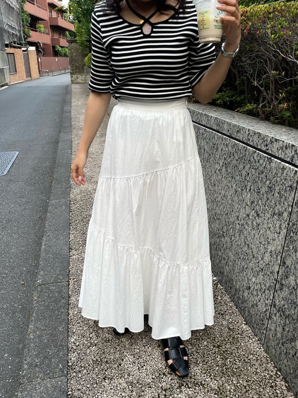 ホワイト系のスカート、ホワイト系のTシャツ/カットソー、ブラック系のサンダルを着用したレディースの夏コーディネートの5枚目の写真