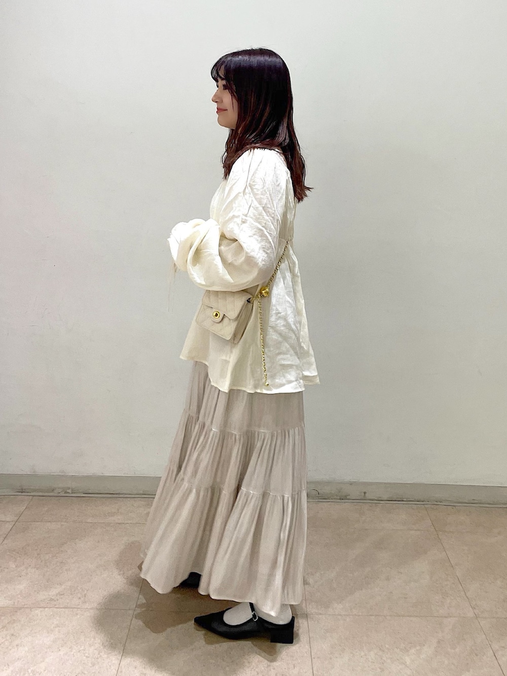 ホワイト系のショルダーバッグ、ホワイト系のシャツ/ブラウス、ホワイト系のスカートを着用したレディースの冬コーディネートの2枚目の写真