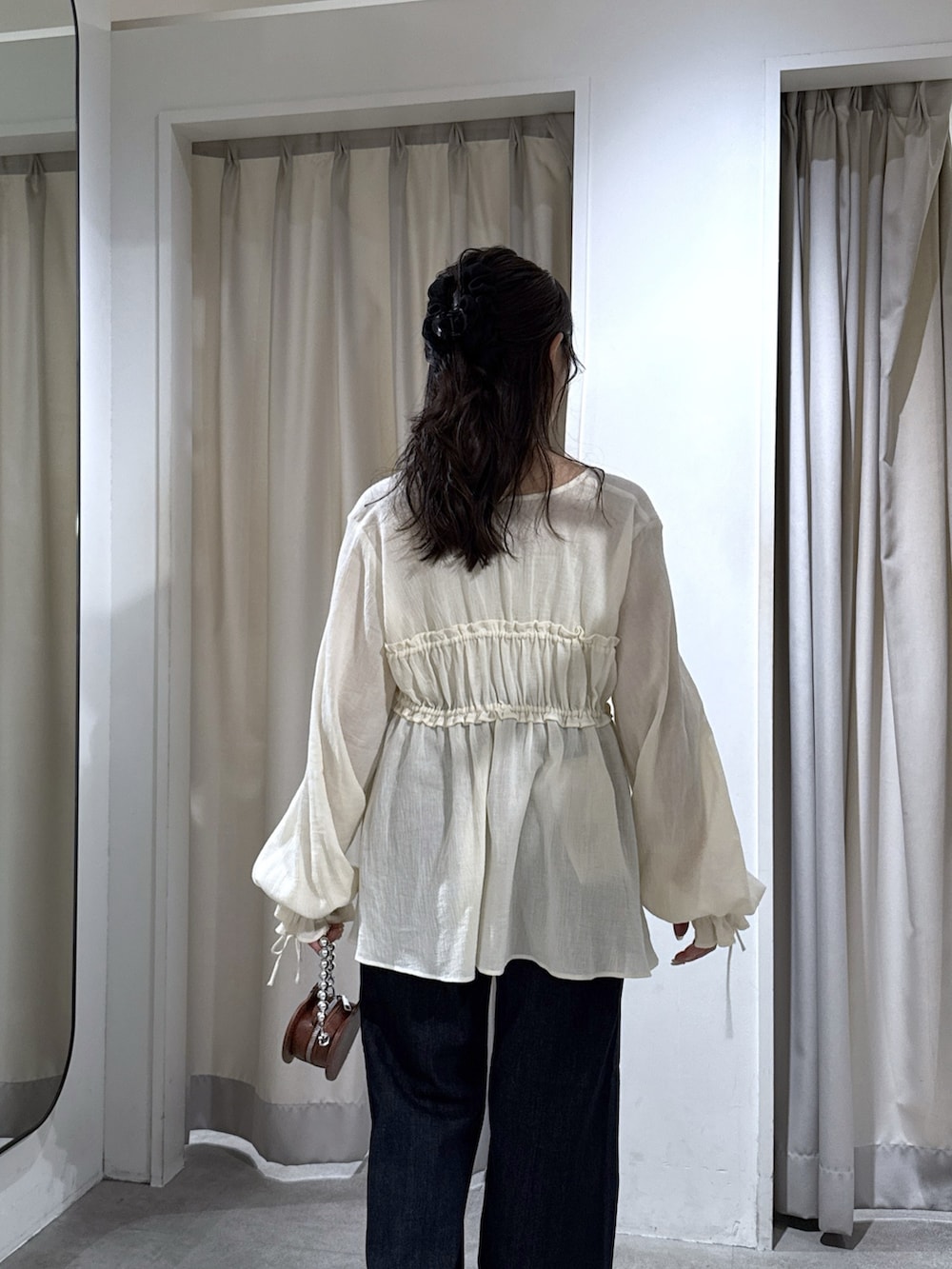 ホワイト系のシャツ/ブラウス、ブルー系のデニムパンツ、ブラック系のパンプスを着用したレディースの秋コーディネートの7枚目の写真