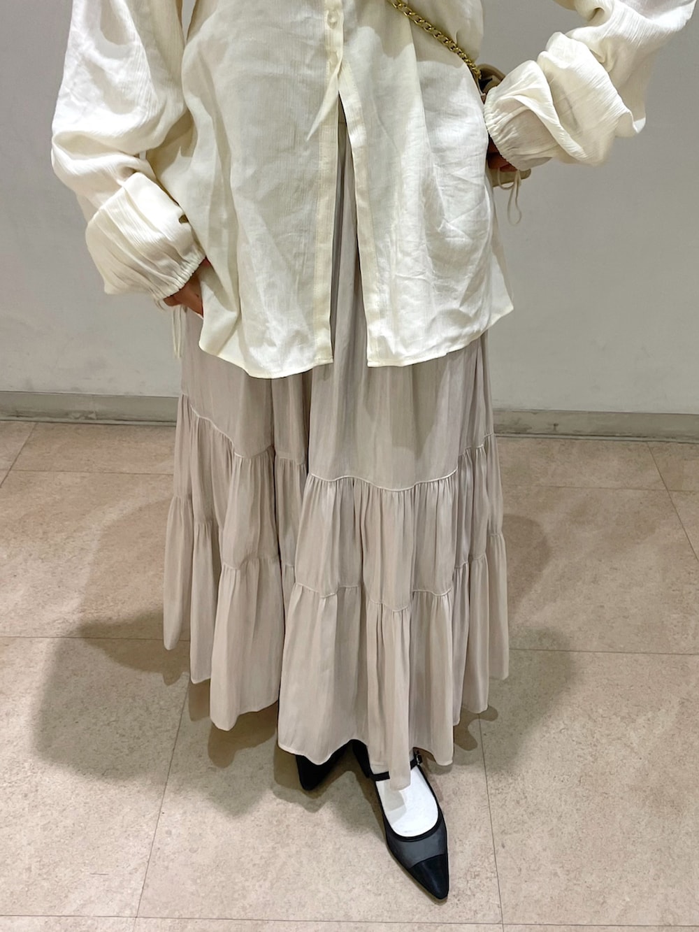 ホワイト系のショルダーバッグ、ホワイト系のシャツ/ブラウス、ホワイト系のスカートを着用したレディースの冬コーディネートの10枚目の写真