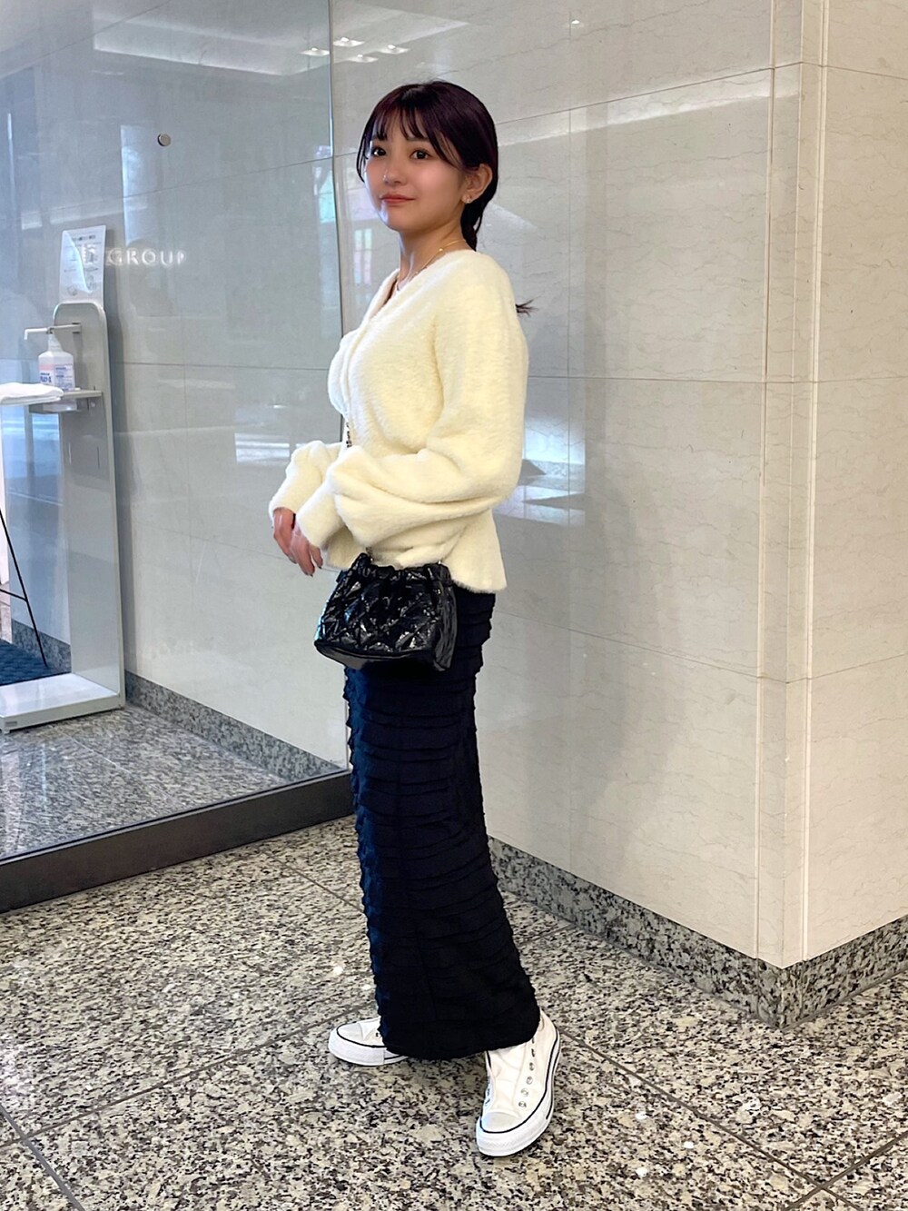 ホワイト系のカーディガン/ボレロ、ブラック系のスカート、ブラック系のショルダーバッグを着用したレディースの冬コーディネートの2枚目の写真