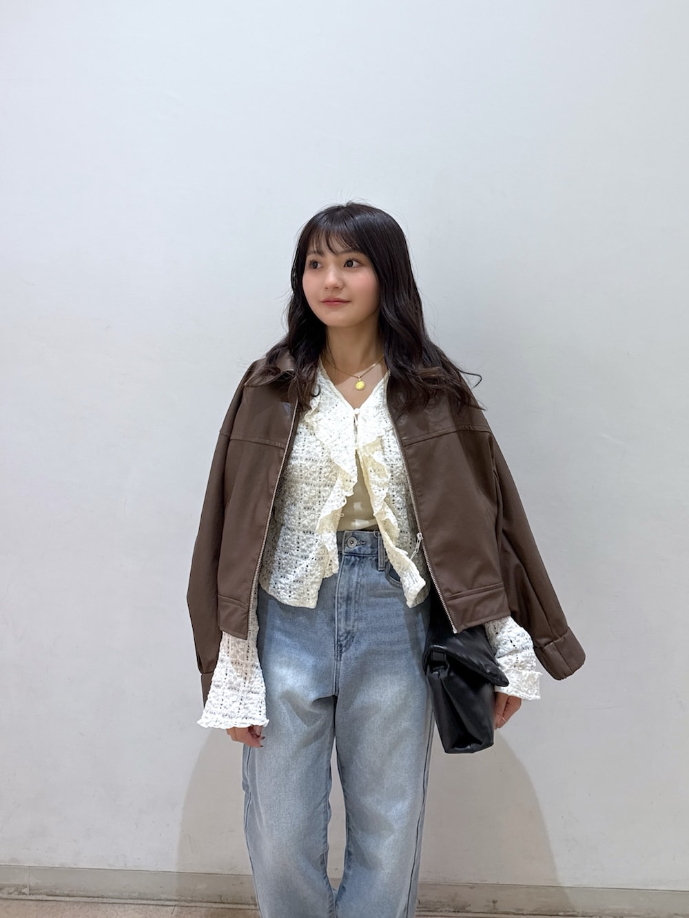 ブラウン系のブルゾン、ホワイト系のシャツ/ブラウス、ホワイト系のキャミソールを着用したレディースの春コーディネートの4枚目の写真