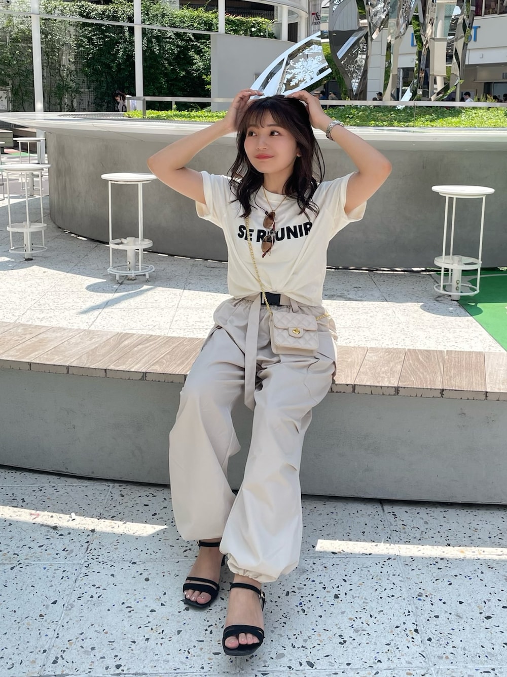 ベージュ系のカーゴパンツ、ホワイト系のTシャツ/カットソー、ホワイト系のショルダーバッグを着用したレディースの夏コーディネートの2枚目の写真