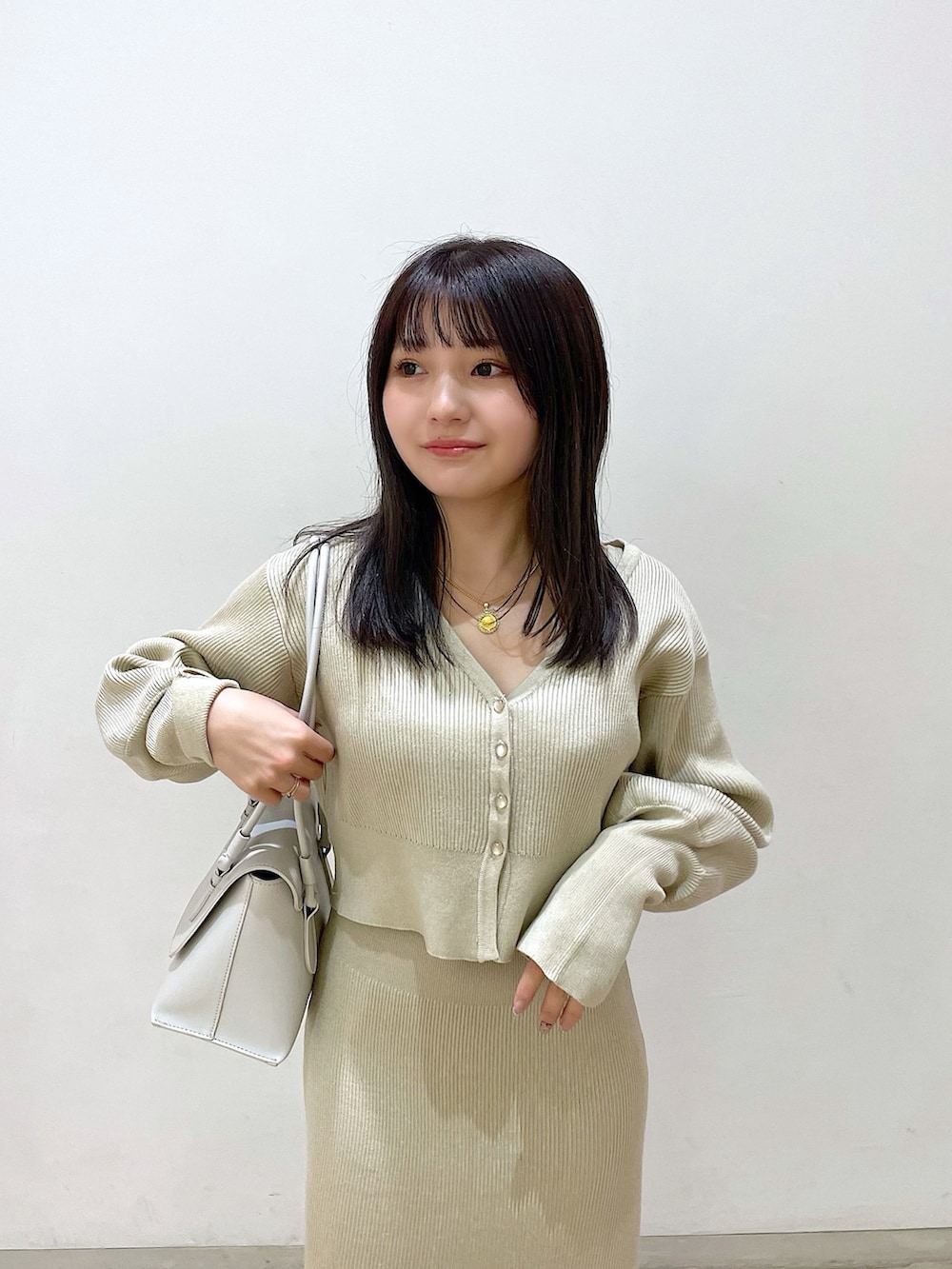 ベージュ系のワンピース、ベージュ系のカーディガン/ボレロ、ブラック系のバレエシューズを着用したレディースの春コーディネートの4枚目の写真