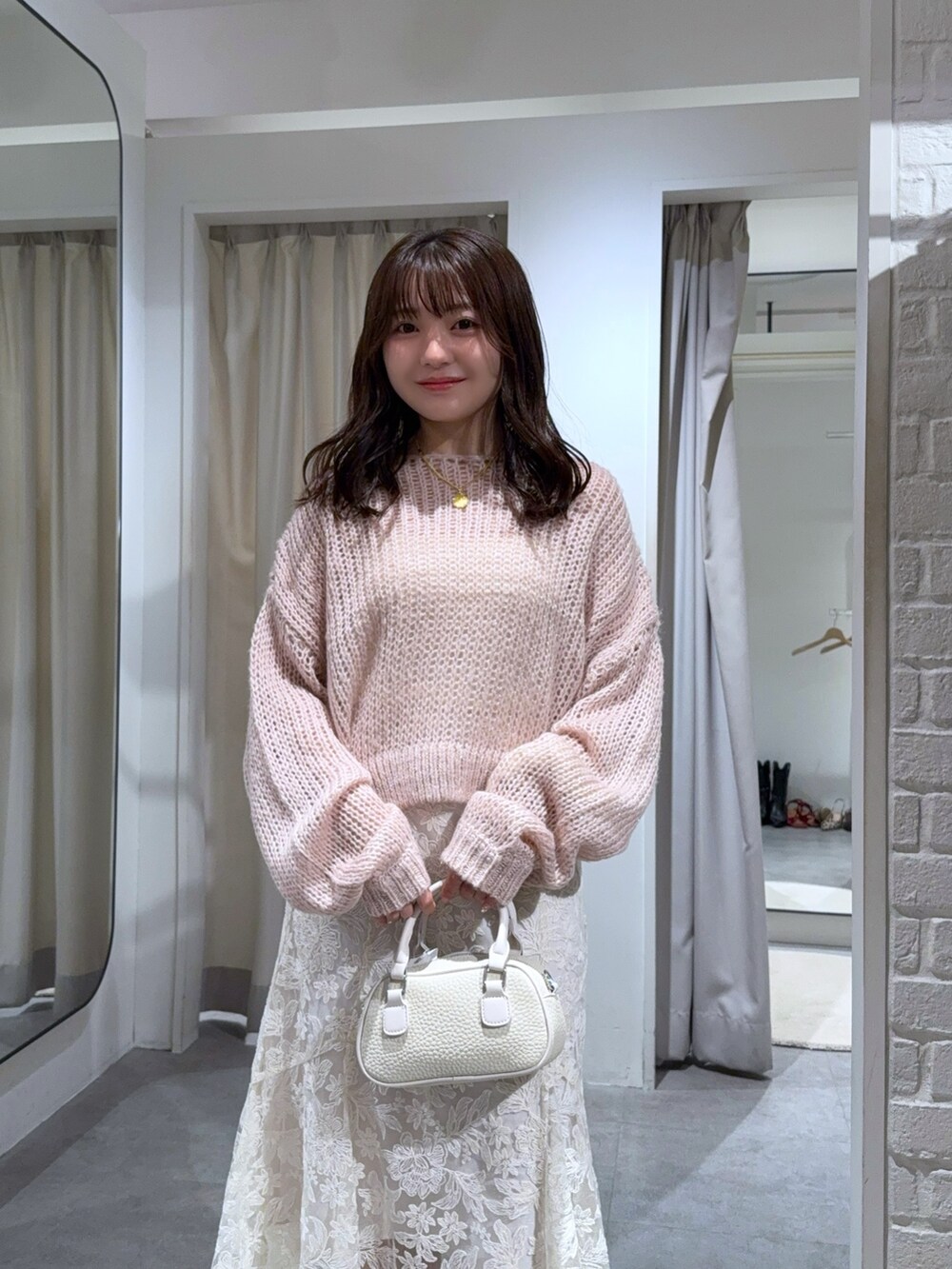 ホワイト系のニット/セーター、ホワイト系のキャミソール、ホワイト系のスカートを着用したレディースの秋コーディネートの4枚目の写真