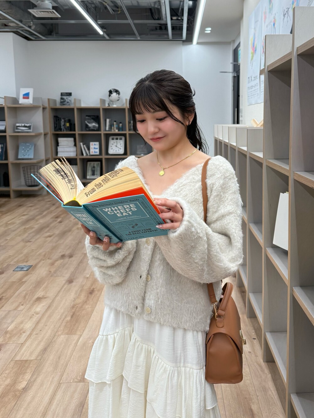 ベージュ系のニット/セーター、ホワイト系のスカート、ベージュ系のトートバッグを着用したレディースの秋コーディネートの4枚目の写真