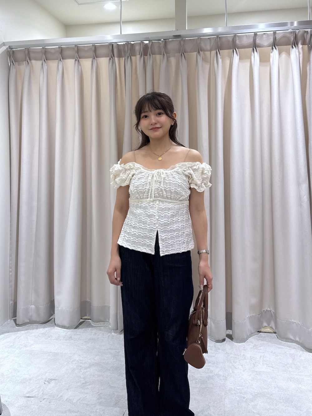 ブラウン系のサンダル、ブルー系のデニムパンツ、ブラウン系のボストンバッグを着用したレディースの夏コーディネートの4枚目の写真