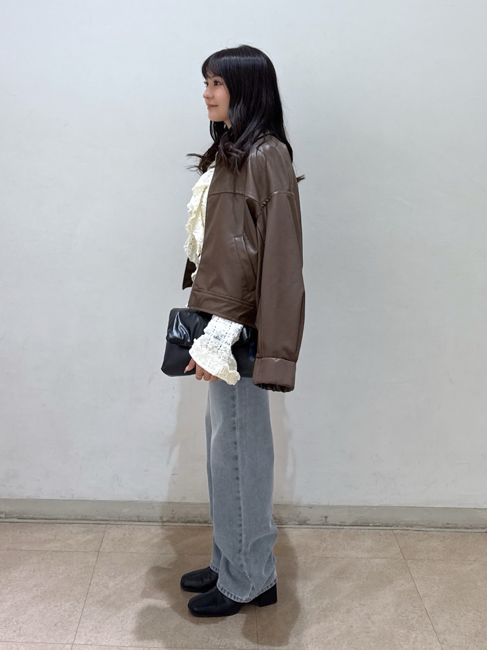 ブラウン系のブルゾン、ホワイト系のシャツ/ブラウス、ホワイト系のキャミソールを着用したレディースの春コーディネートの2枚目の写真