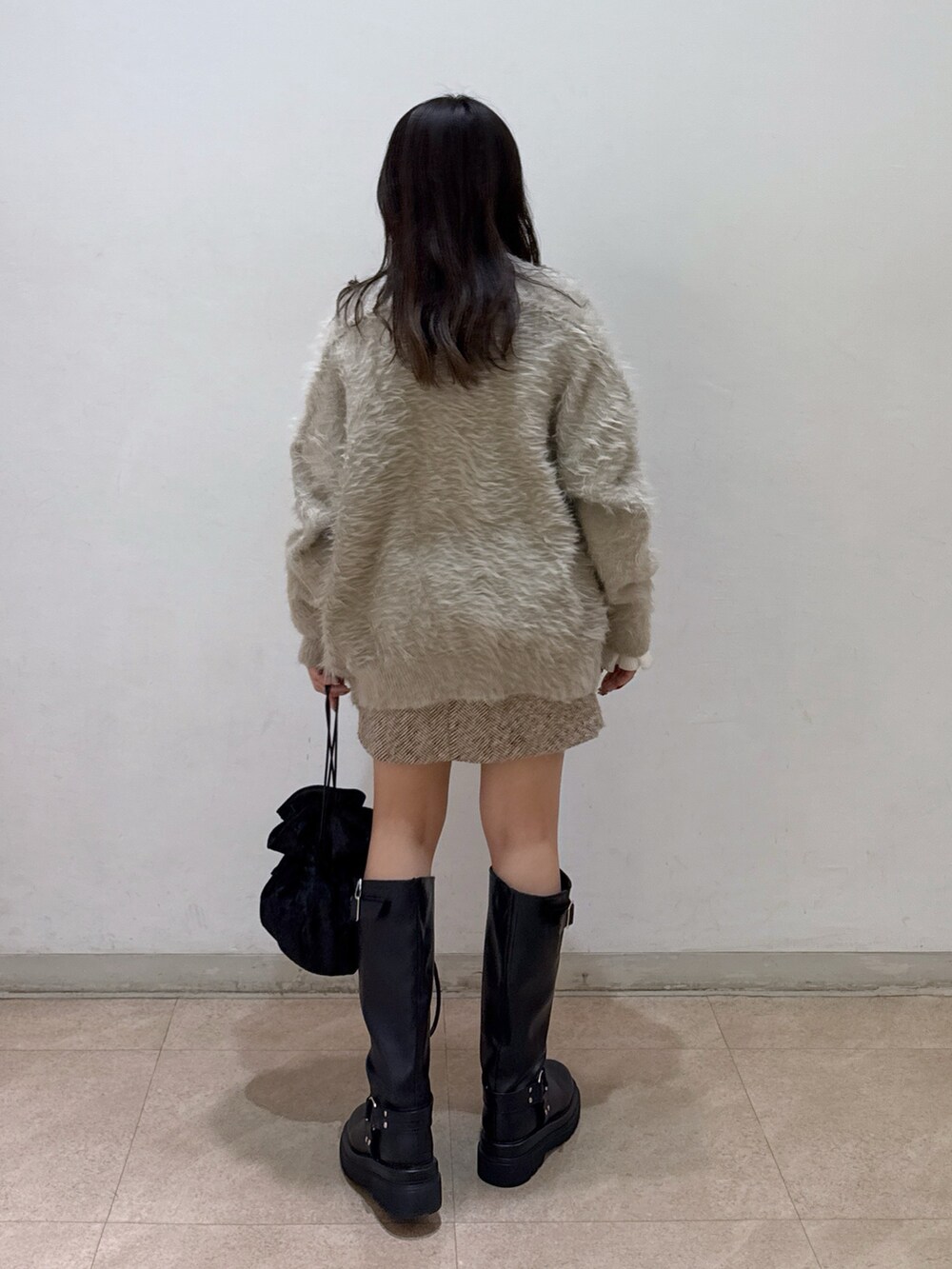 ベージュ系のカーディガン/ボレロ、ホワイト系のニット/セーター、ベージュ系のスカートを着用したレディースの冬コーディネートの3枚目の写真