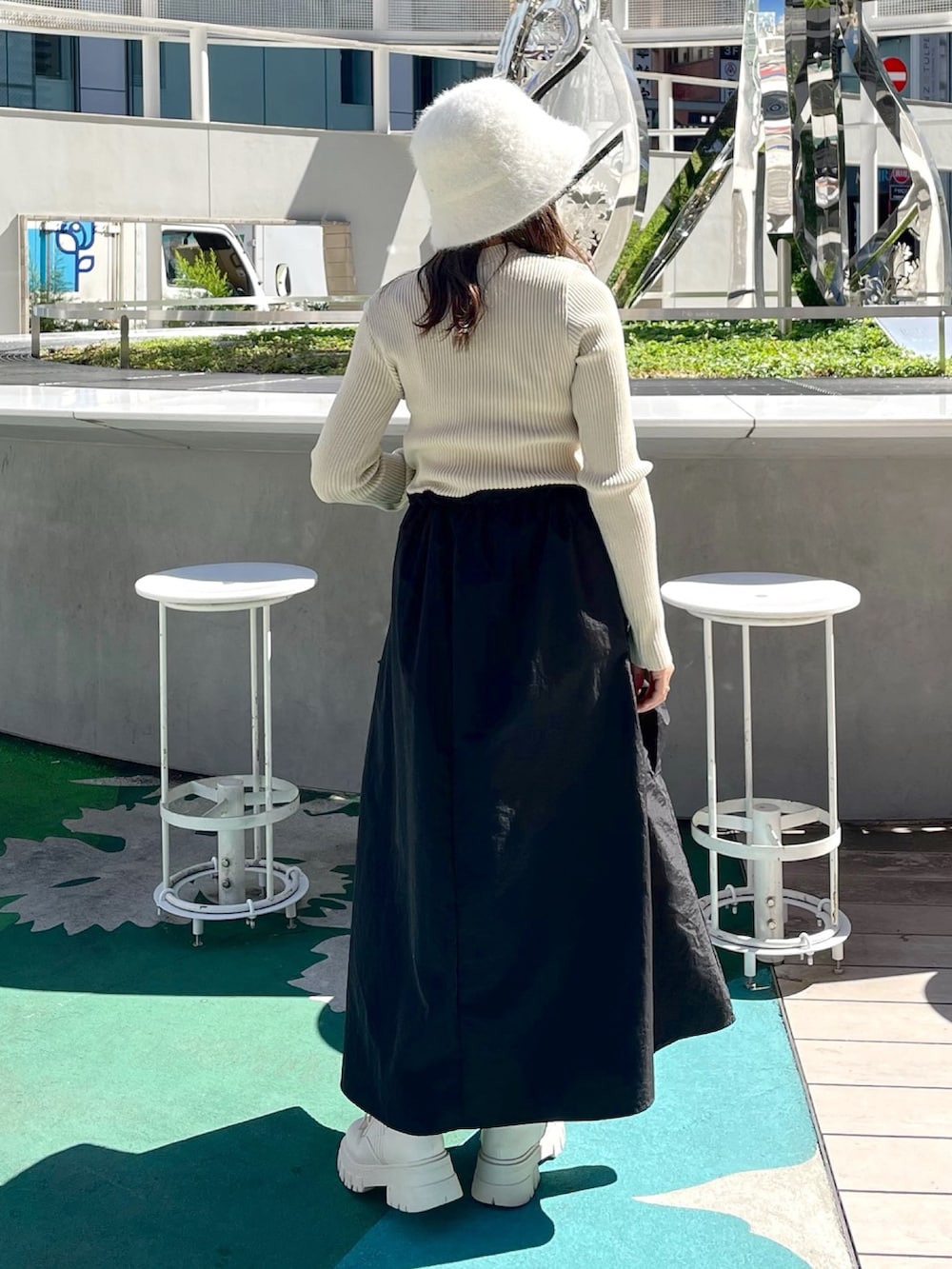 ホワイト系のワンピース、ブラック系のハンドバッグ、ホワイト系のブーツを着用したレディースの秋コーディネートの3枚目の写真