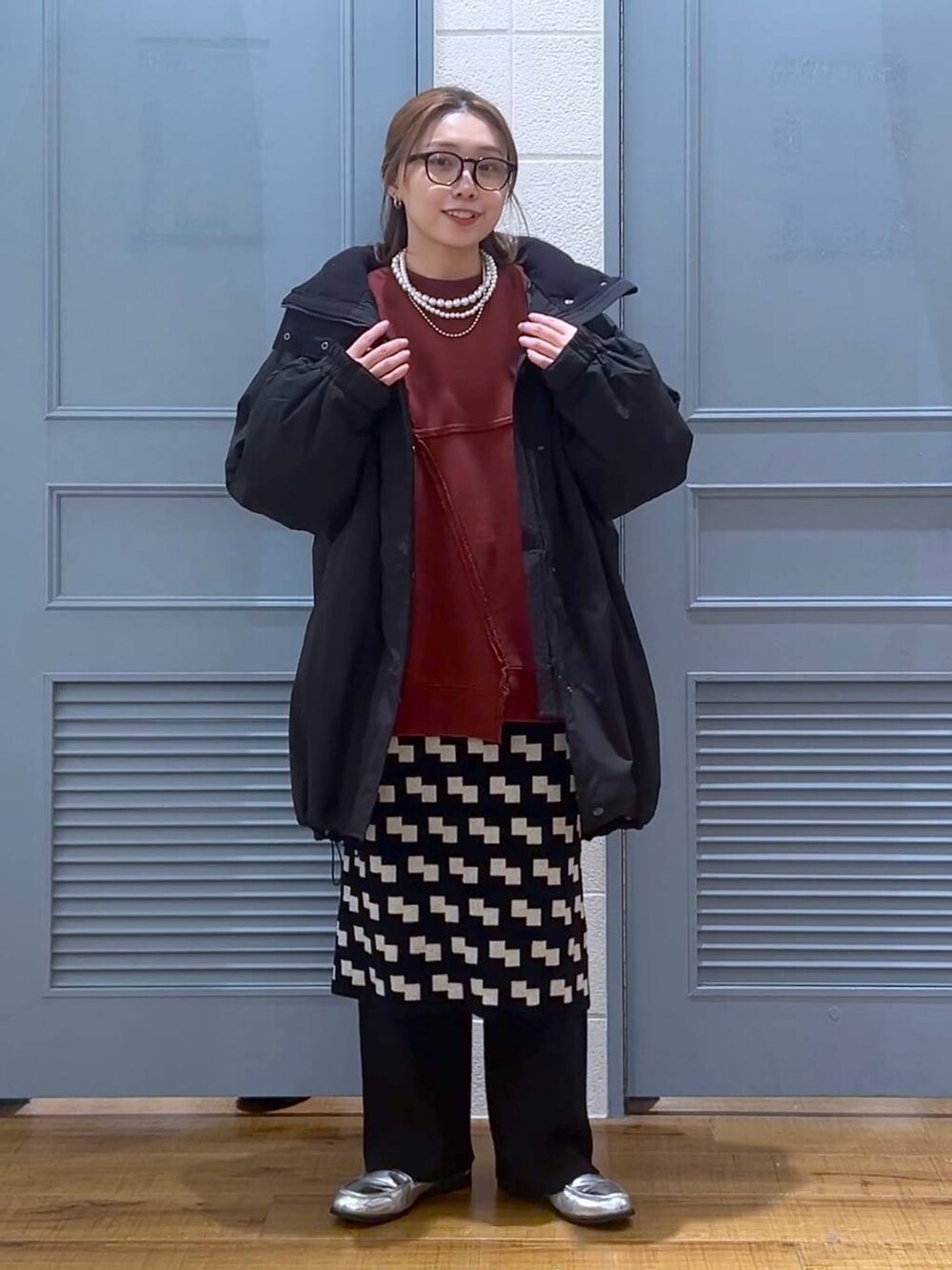 ブラック系のその他アウター、シルバー系のローファー、ブラック系のスカートを着用したレディースの冬コーディネートの2枚目の写真