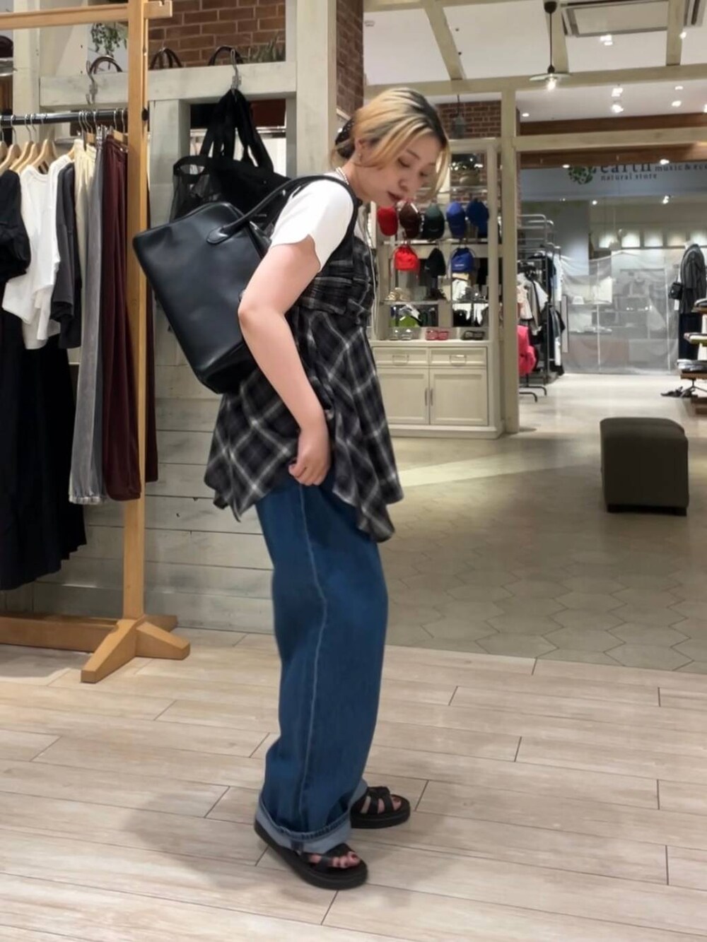 ホワイト系のTシャツ/カットソー、ブラック系のサンダル、ブルー系のデニムパンツを着用したレディースの夏コーディネートの2枚目の写真