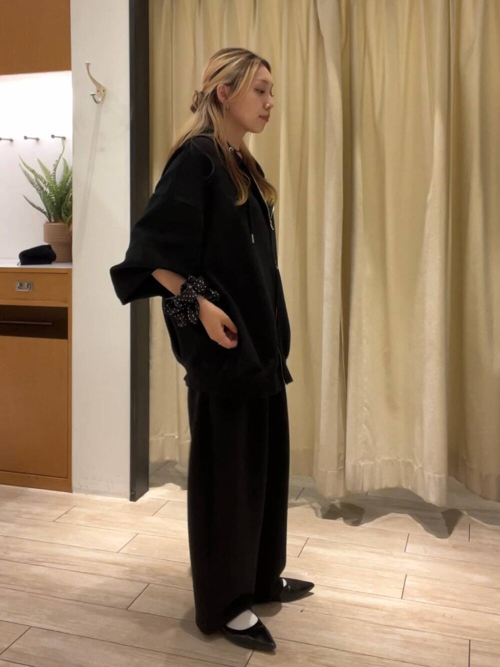 ブラック系のスウェットパンツ、ブラック系のパーカー、ブラック系のパンプスを着用したレディースの秋コーディネートの2枚目の写真