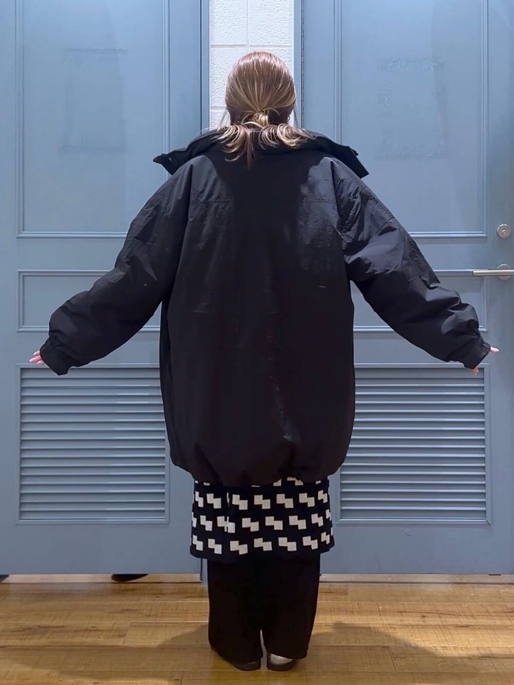 ブラック系のその他アウター、シルバー系のローファー、ブラック系のスカートを着用したレディースの冬コーディネートの3枚目の写真