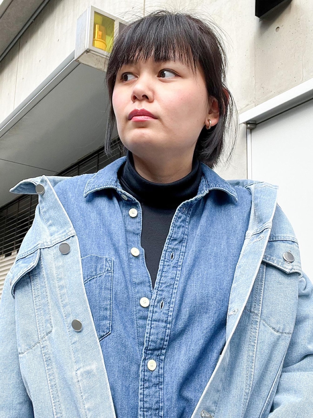 ブルー系のデニムジャケット、ブルー系のシャツ/ブラウス、ブルー系のハンドバッグを着用したレディースの秋コーディネートの4枚目の写真