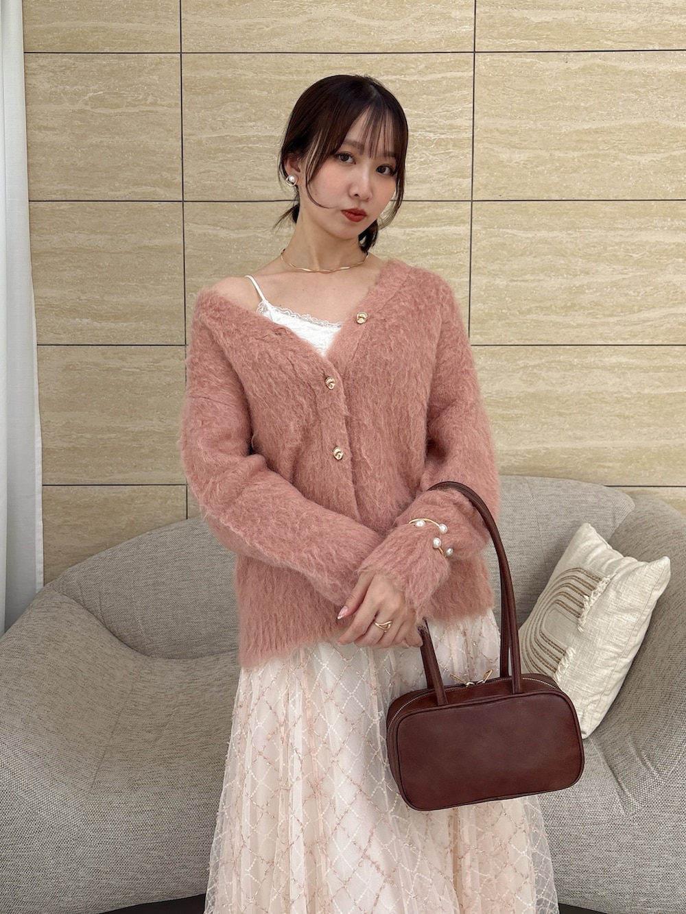 ピンク系のカーディガン/ボレロ、ブラウン系のハンドバッグを着用したレディースの秋コーディネートの6枚目の写真