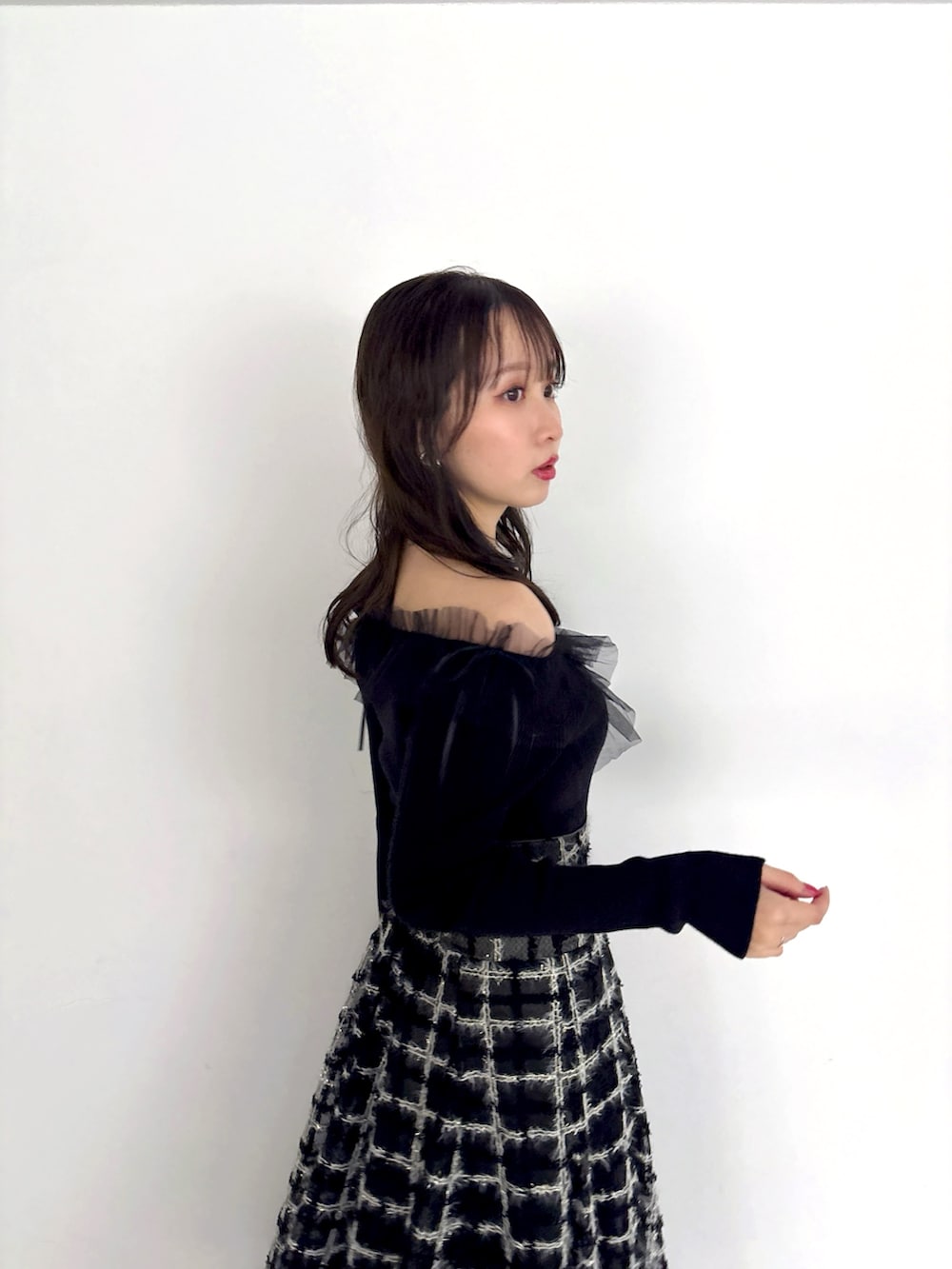 ブラック系のニット/セーター、ブラック系のスカート、ブラック系のブーツを着用したレディースの秋コーディネートの6枚目の写真