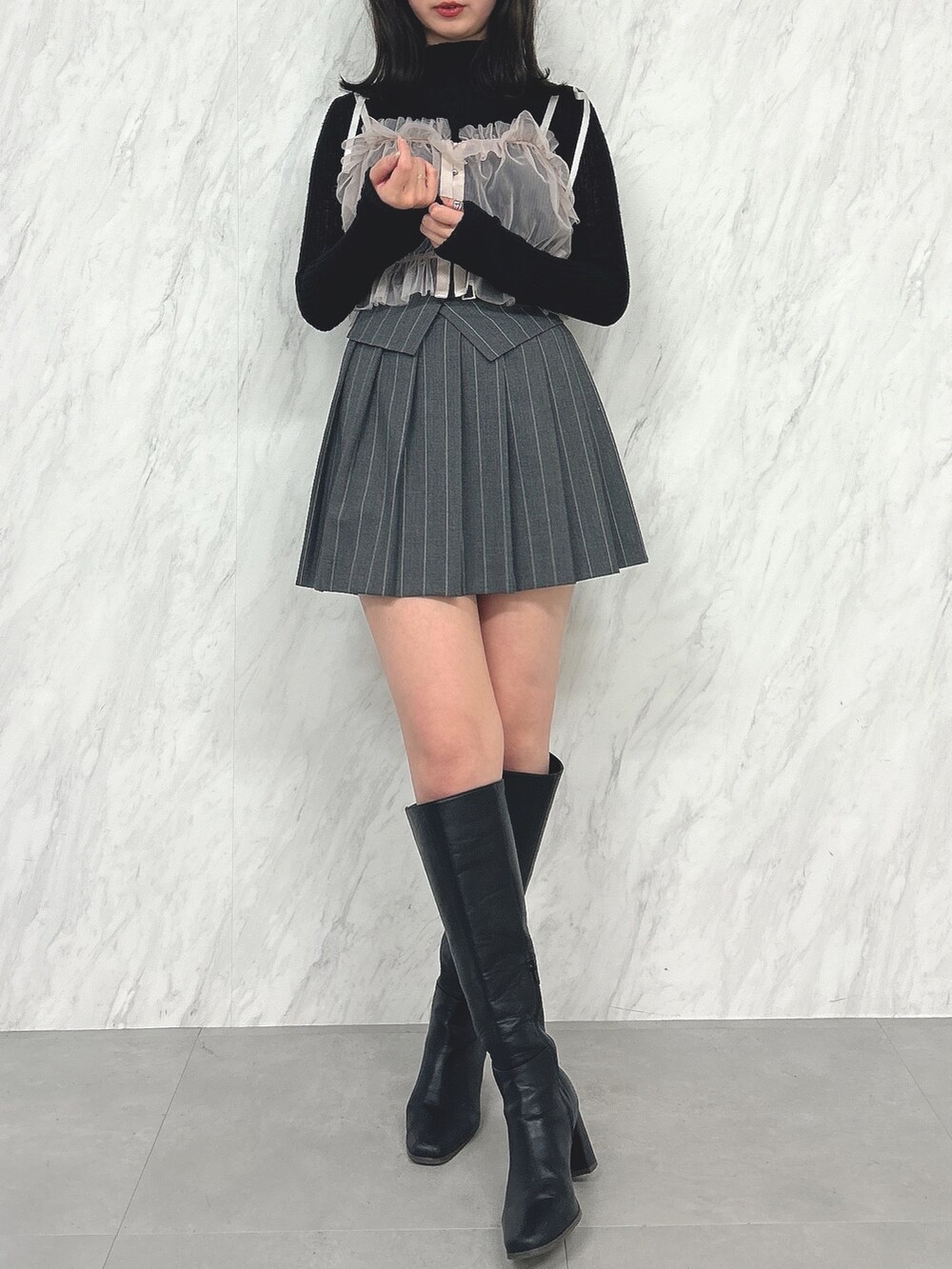 ピンク系のキャミソール、ブラック系のニット/セーター、グレー系のスカートを着用したレディースの冬コーディネートの2枚目の写真