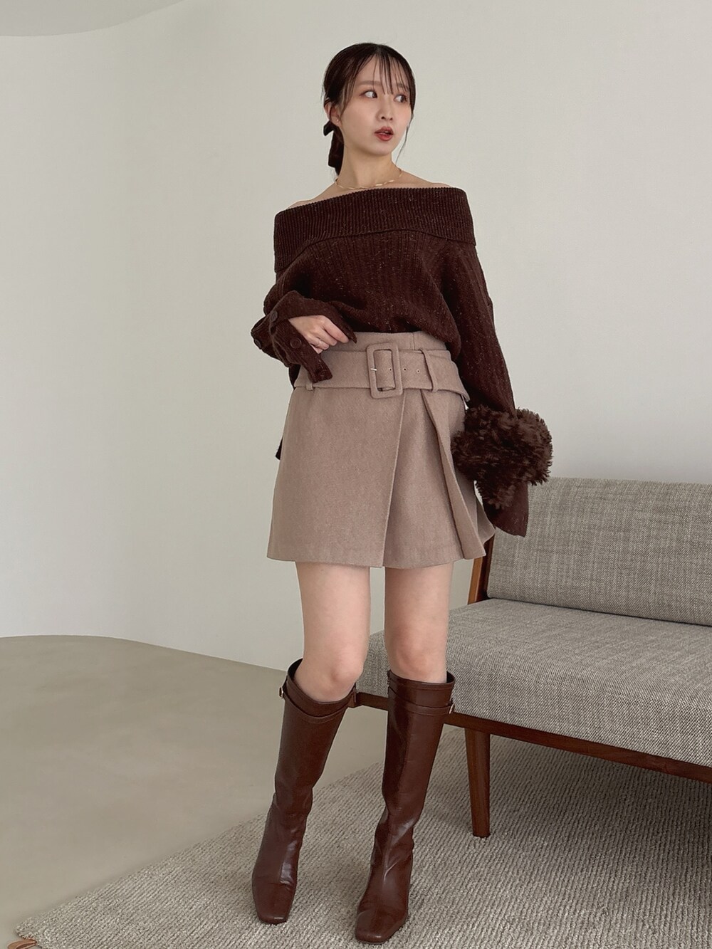 ブラウン系のニット/セーター、ブラウン系のスカート、ブラウン系のブーツを着用したレディースの秋コーディネートの2枚目の写真